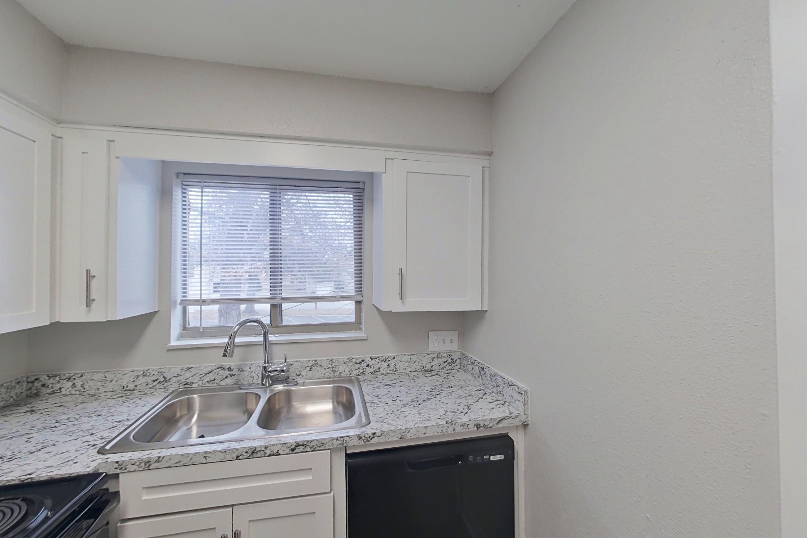 Kitchen with black appliances, dishwasher, electric range, light countertops, light stone countertops, and oven/range, Apartment 1402D at The Life at Legacy Fountains
