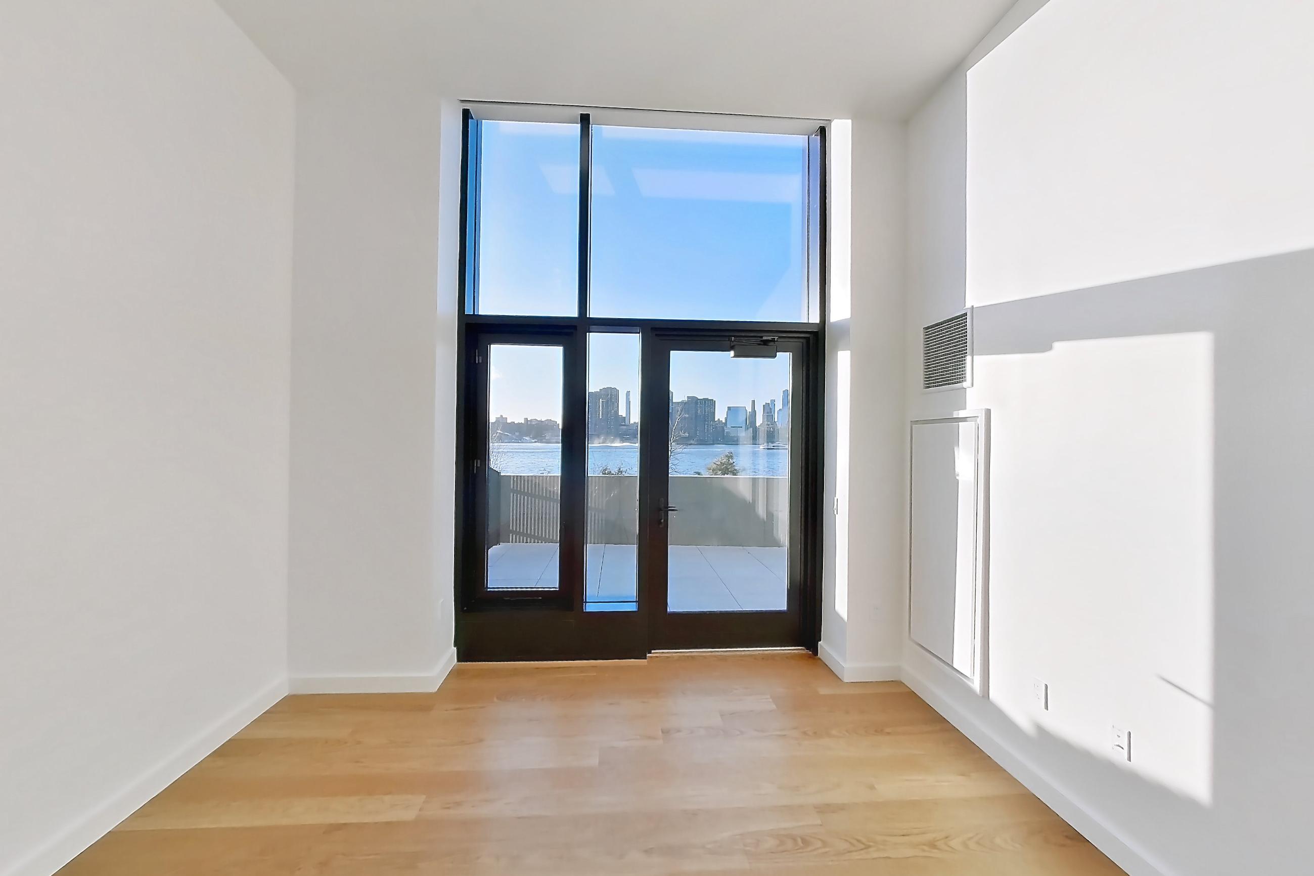 Living room with light wood-finish flooring, Apartment 1-1002 at Cortland Rosslyn