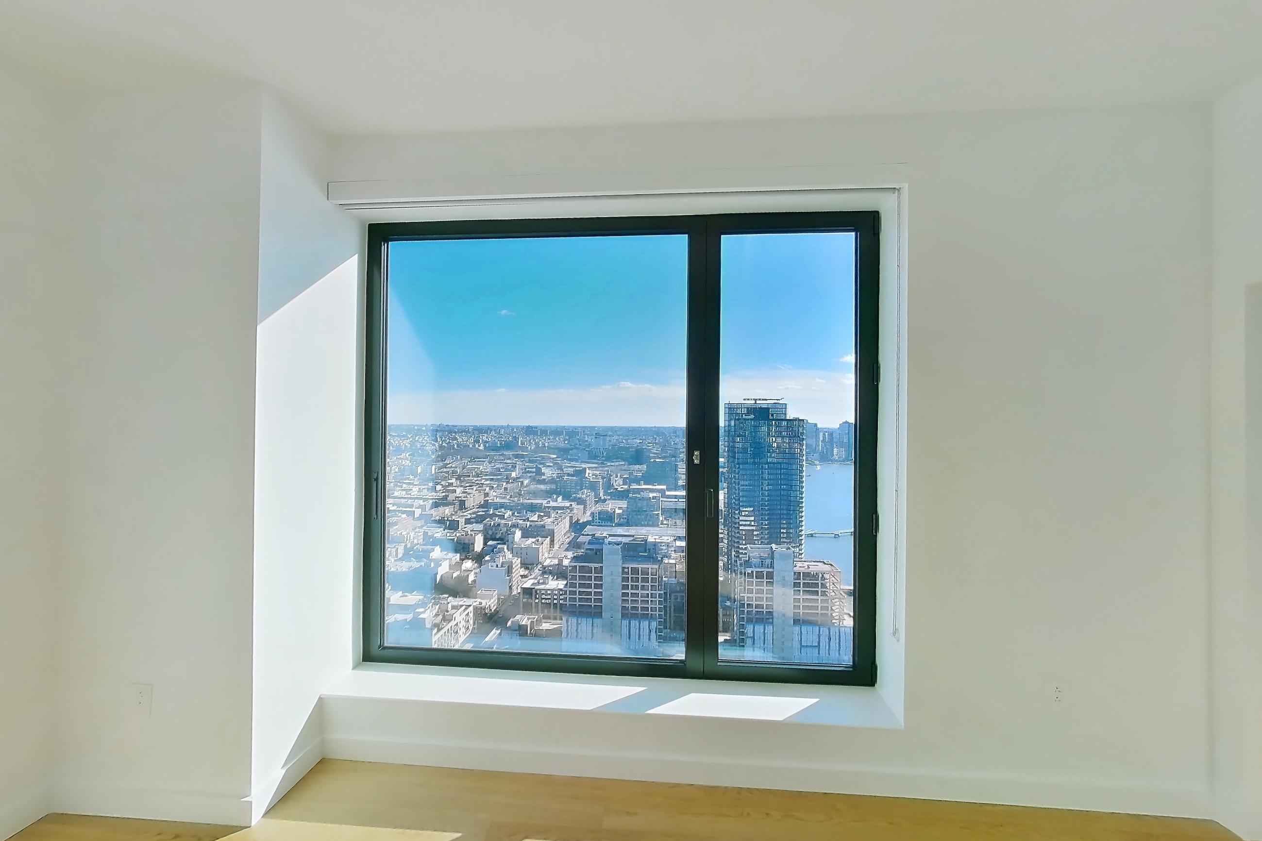 Living room with city view and light wood-finish flooring, Apartment 1-PH2G at Eagle + West