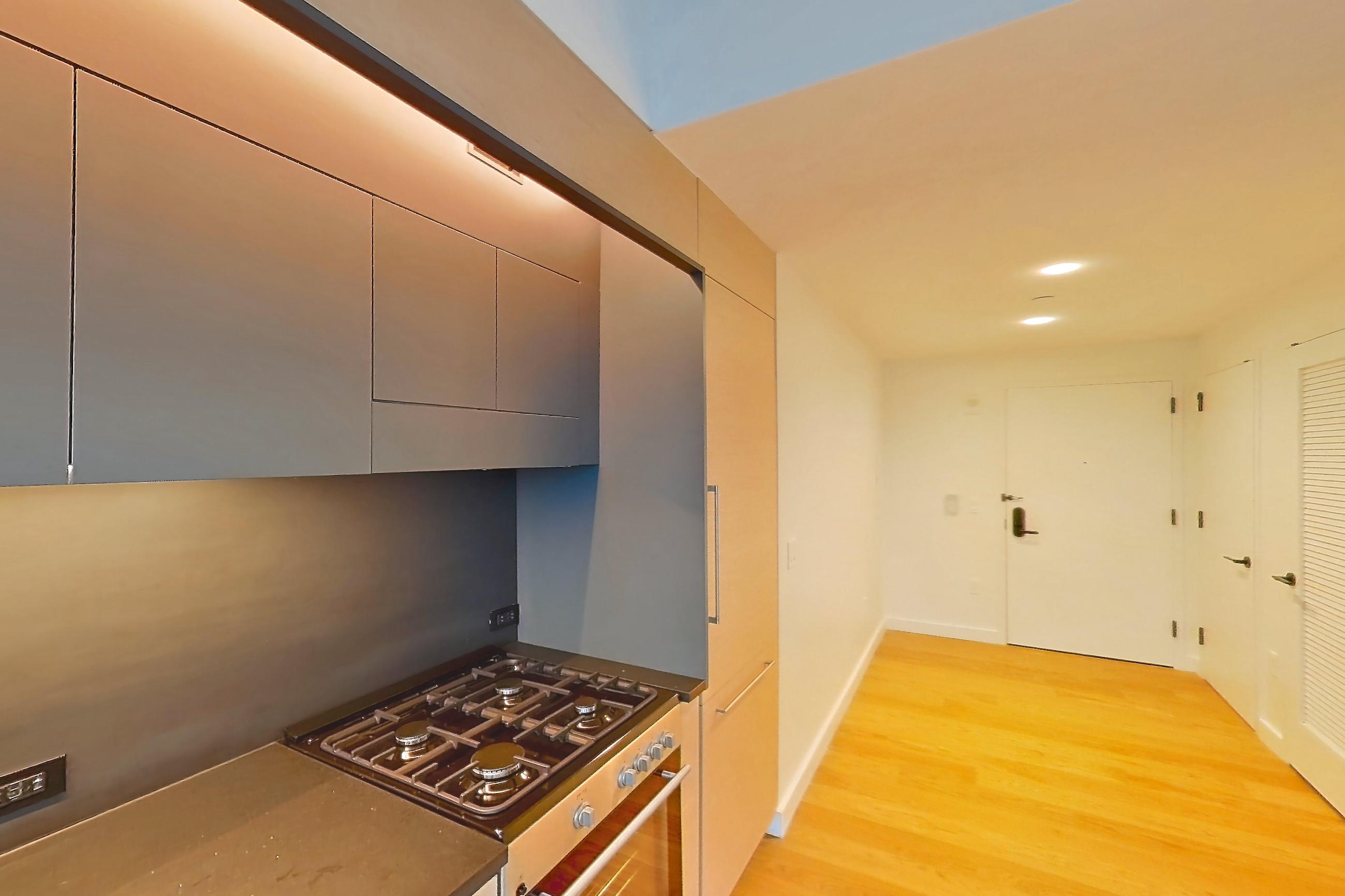 Kitchen with gas range, light wood-finish flooring, oven/range, and stainless steel appliances, Apartment 1-PH4A at Eagle + West