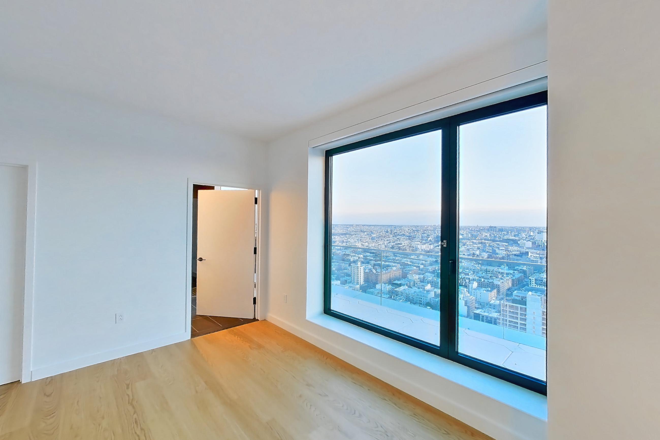 Living space with city view and light wood-finish flooring, Apartment 1-PH4A at Eagle + West
