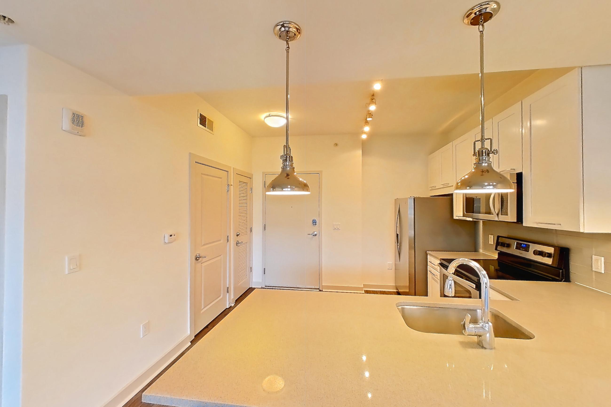 Dining room with dark wood-finish flooring and light stone countertops, Apartment 0203 at Cyan on Peachtree