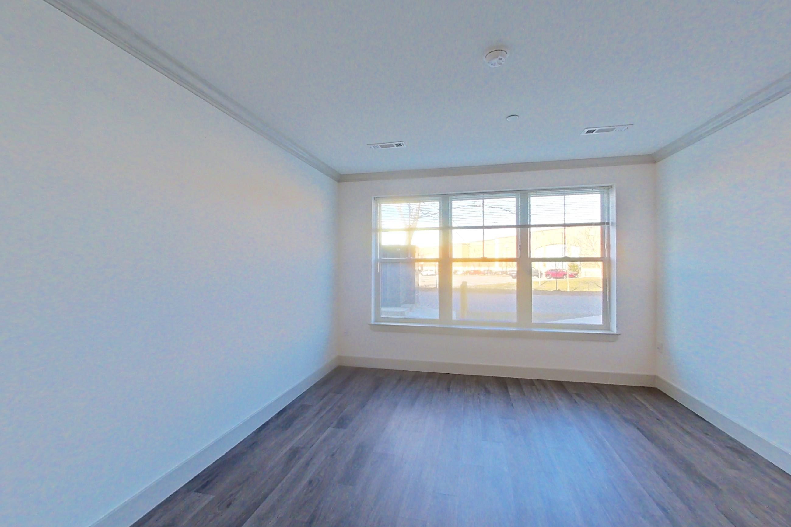 Living room with dark wood-finish flooring, Apartment 1081 at Carraway NY