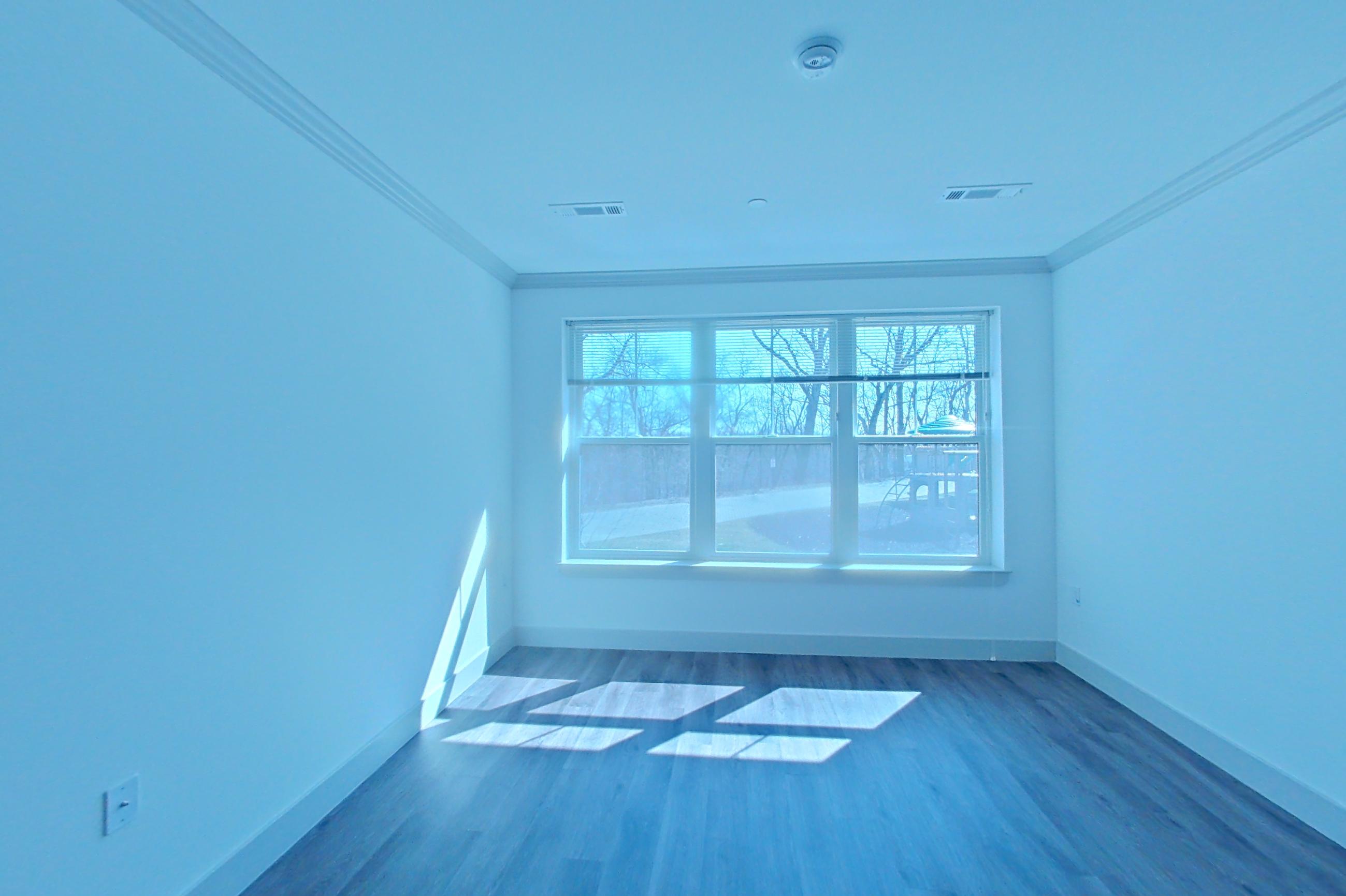 Living room with dark wood-finish flooring, Apartment 1092 at Carraway NY