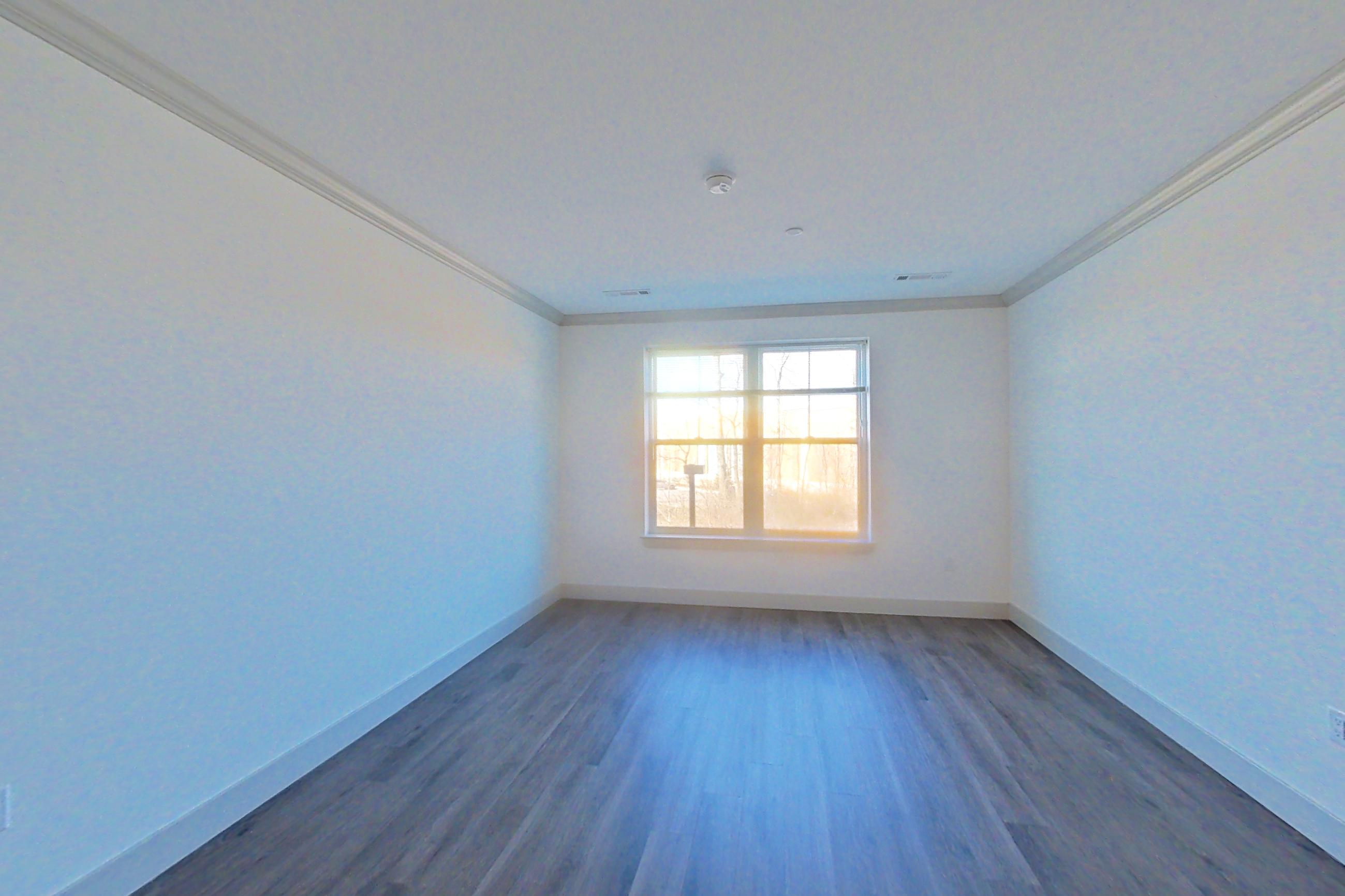Living room with dark wood-finish flooring, Apartment 2087 at Carraway NY