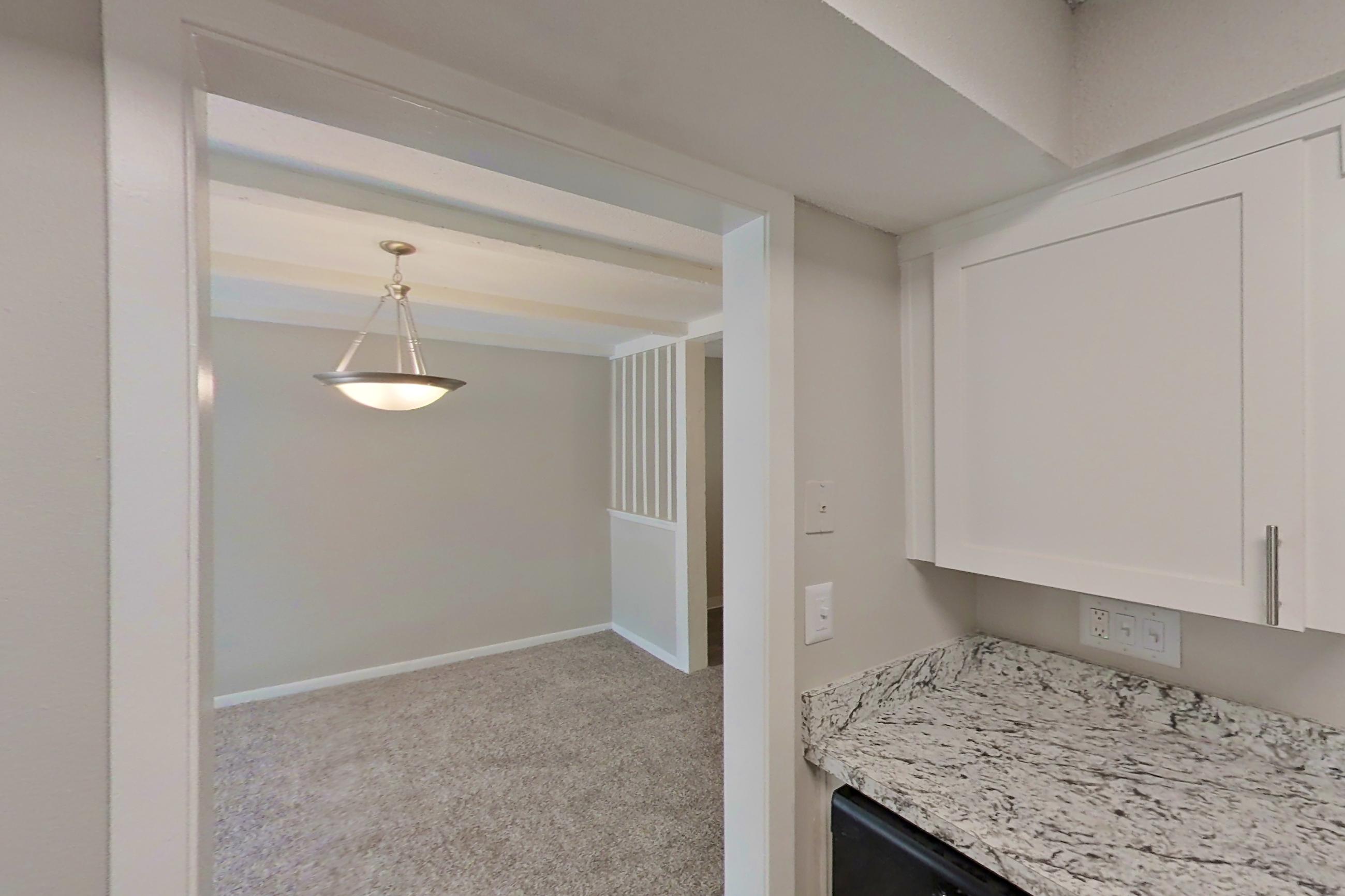 Kitchen with black appliances, dark wood-finish flooring, electric range, light countertops, light stone countertops, oven/range, and refrigerator, Apartment 1502C at The Life at Legacy Fountains