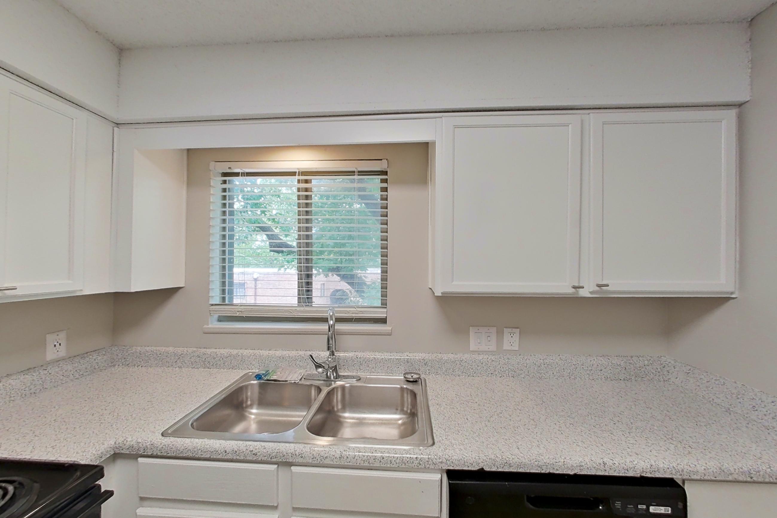 Kitchen with black appliances, dishwasher, electric range, light countertops, light stone countertops, oven/range, and refrigerator, Apartment 1406C at The Life at Legacy Fountains
