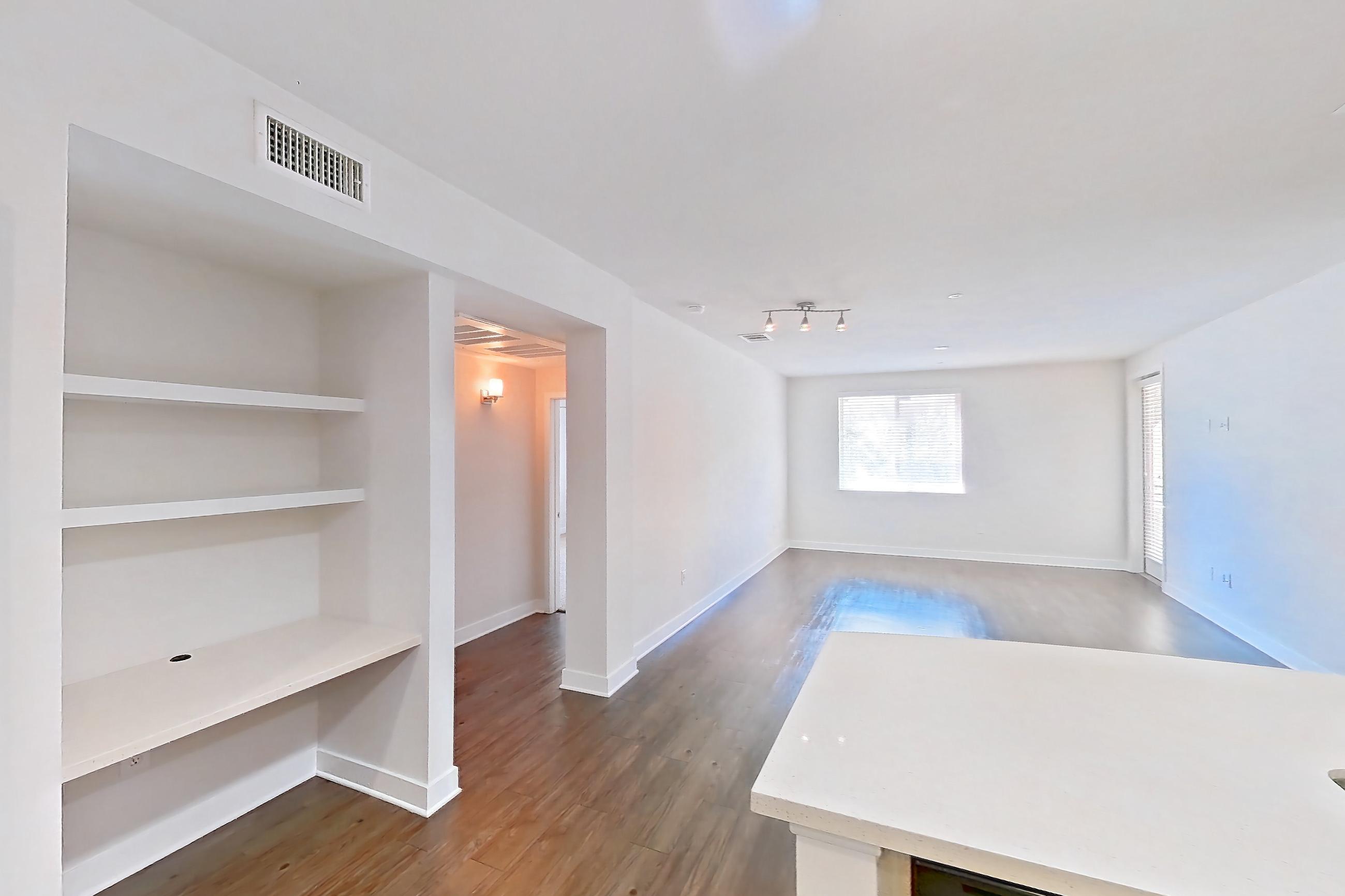 Kitchen with dark wood-finish flooring, dishwasher, gas range, light countertops, light wood-finish flooring, microwave, oven/range, refrigerator, and stainless steel appliances, Apartment 2576 at The Verge Apartments