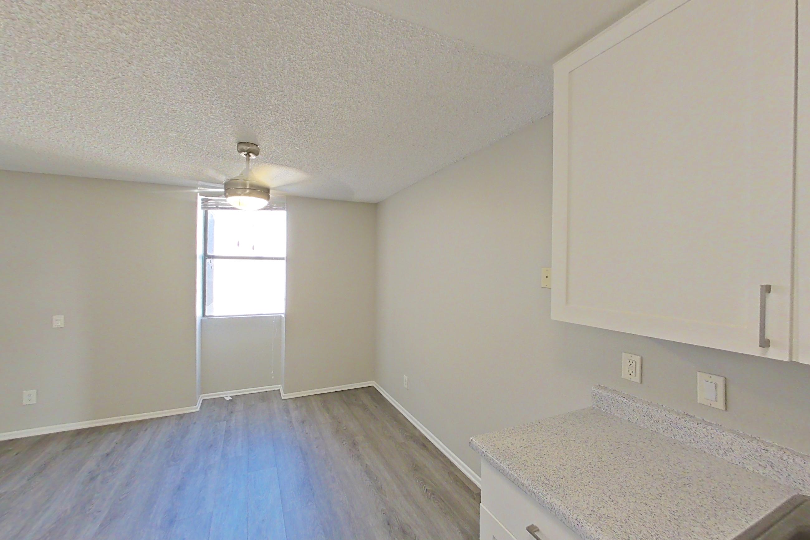Kitchen with dishwasher, electric range, light countertops, light stone countertops, light wood-finish flooring, microwave, oven/range, refrigerator, stainless steel appliances, and white appliances, Apartment 01-05 at Avana Rancho Cucamonga