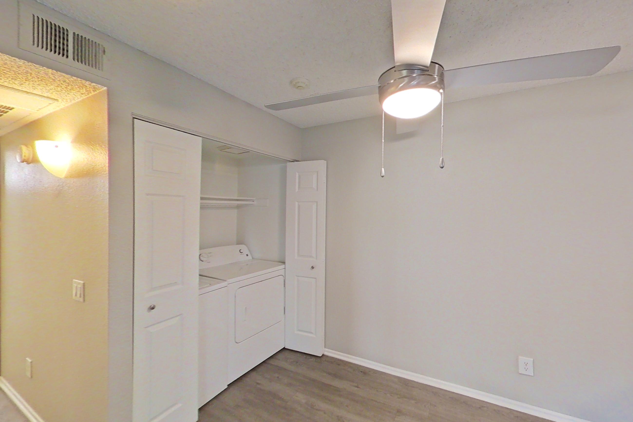 Dining area with dark wood-finish flooring, dishwasher, electric range, in-unit laundry, light countertops, light wood-finish flooring, refrigerator, and stainless steel appliances, Apartment 04-04 at Avana Rancho Cucamonga