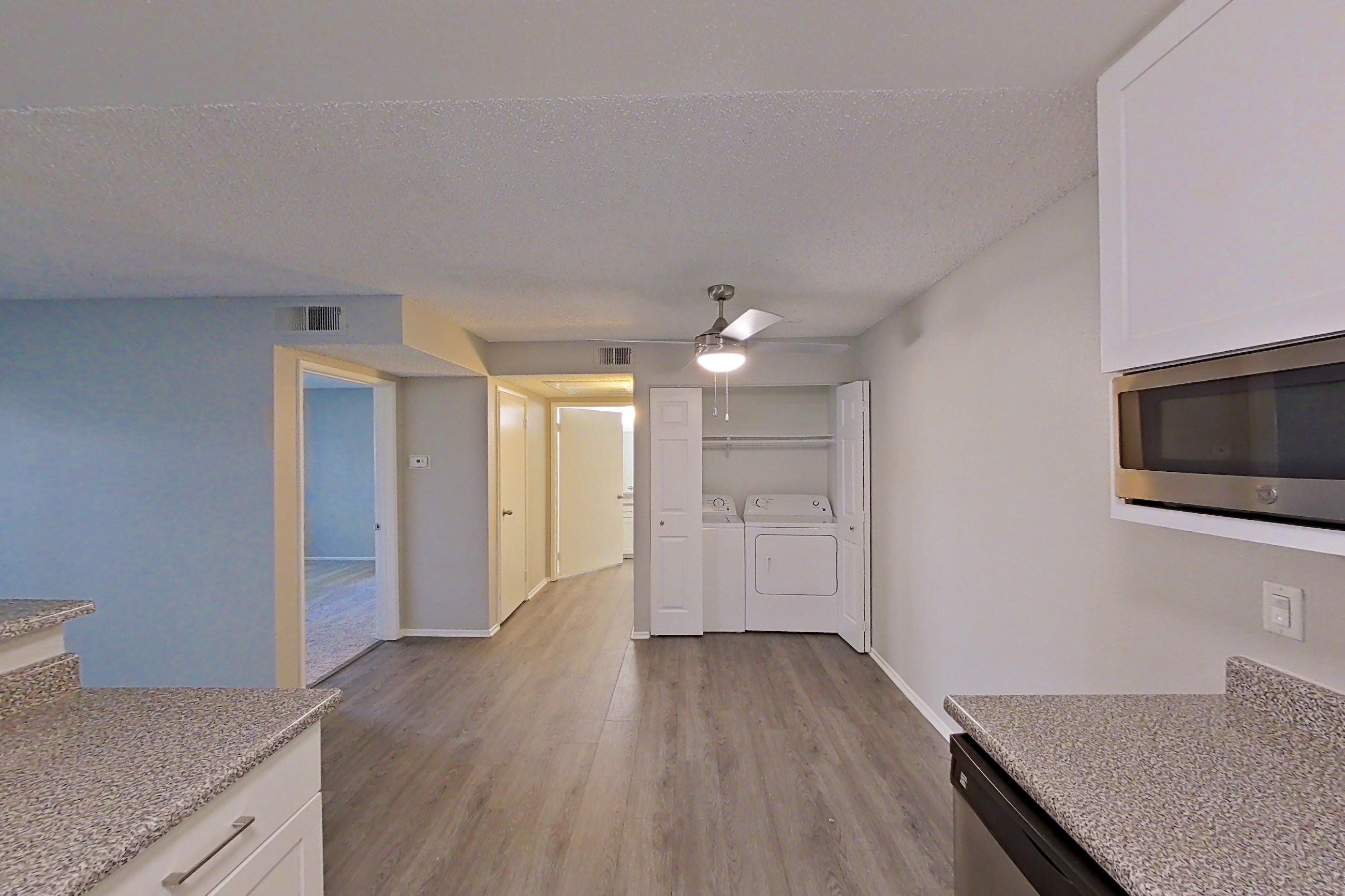Kitchen with dishwasher, electric range, light countertops, light wood-finish flooring, microwave, oven/range, refrigerator, and stainless steel appliances, Apartment 04-04 at Avana Rancho Cucamonga