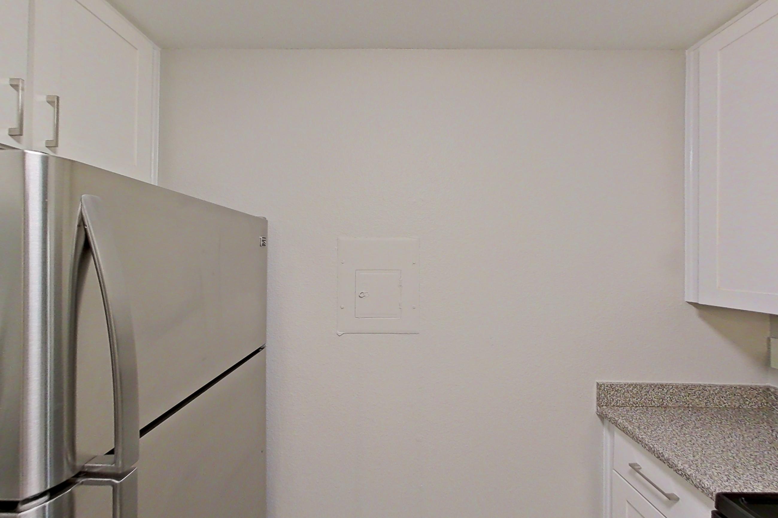 Kitchen with dishwasher, electric range, light countertops, light wood-finish flooring, microwave, oven/range, refrigerator, and stainless steel appliances, Apartment 04-04 at Avana Rancho Cucamonga