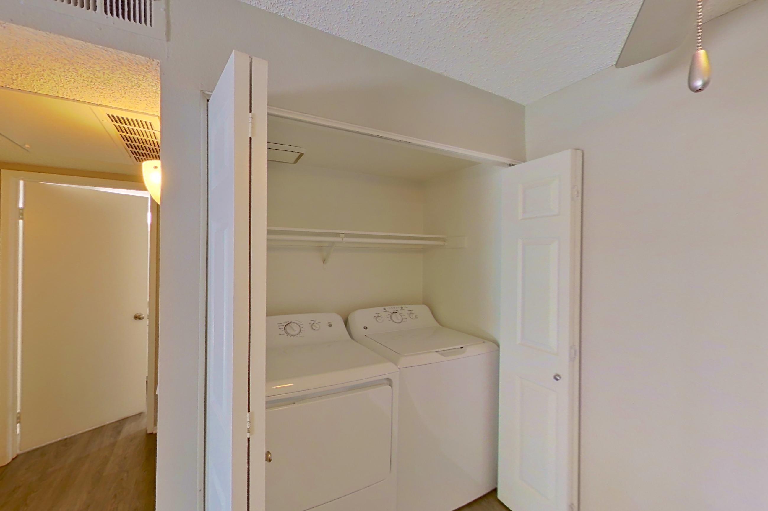 Dining space with dishwasher, electric range, in-unit laundry, light stone countertops, light wood-finish flooring, refrigerator, and stainless steel appliances, Apartment 04-05 at Avana Rancho Cucamonga