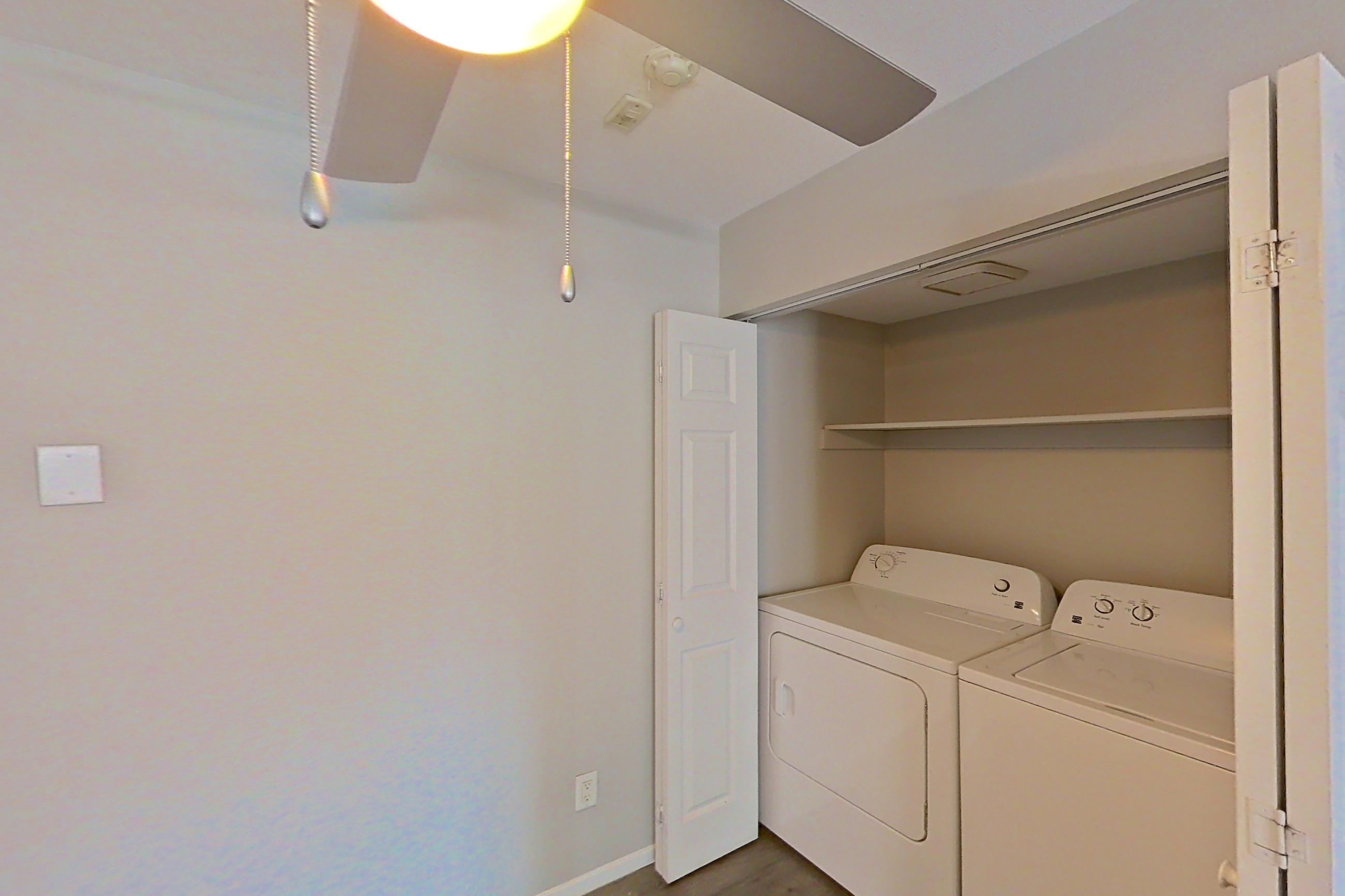 Dining area with dishwasher, electric range, in-unit laundry, light countertops, light wood-finish flooring, refrigerator, and stainless steel appliances, Apartment 05-03 at Avana Rancho Cucamonga