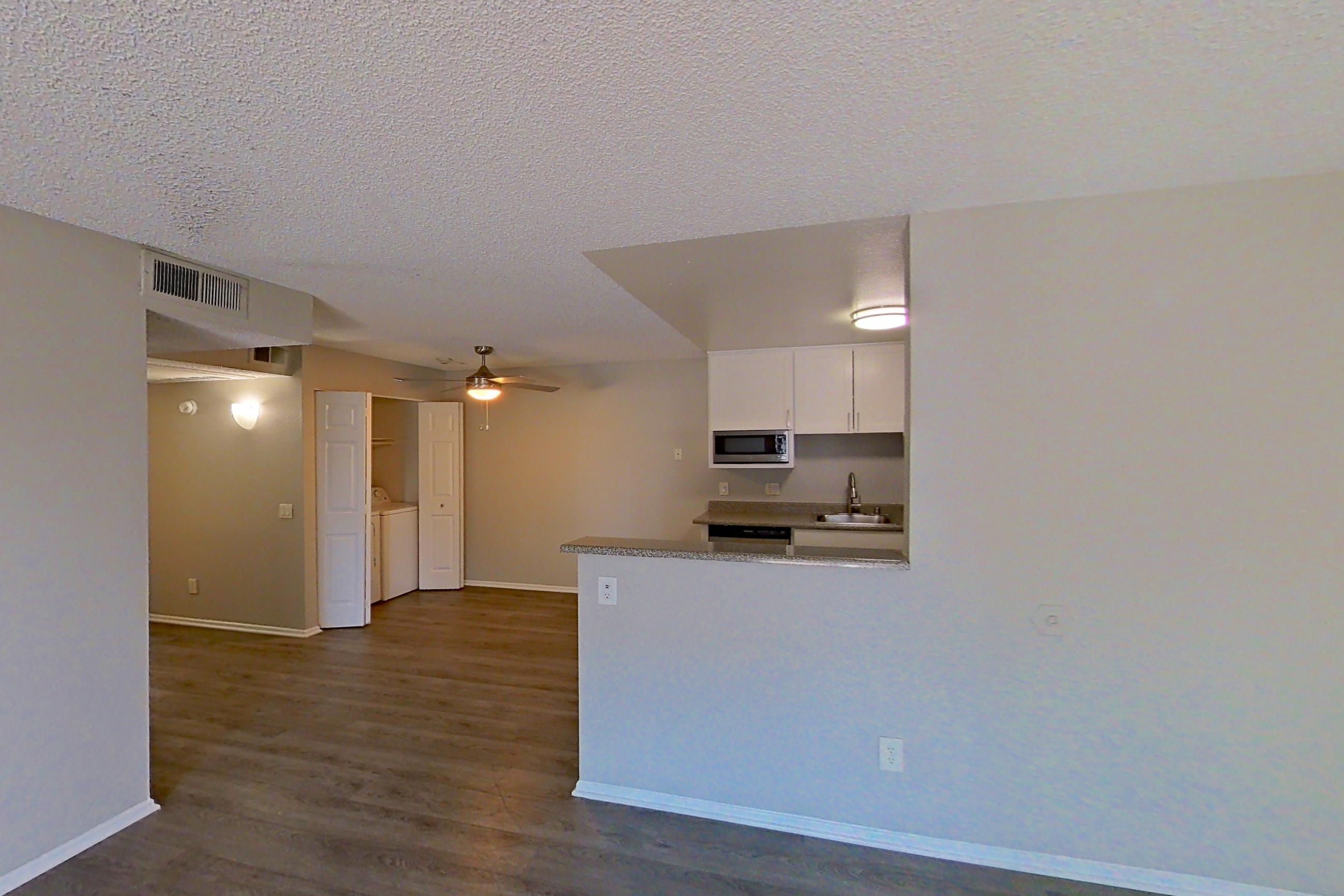Living room with dark wood-finish flooring, Apartment 05-05 at Avana Rancho Cucamonga