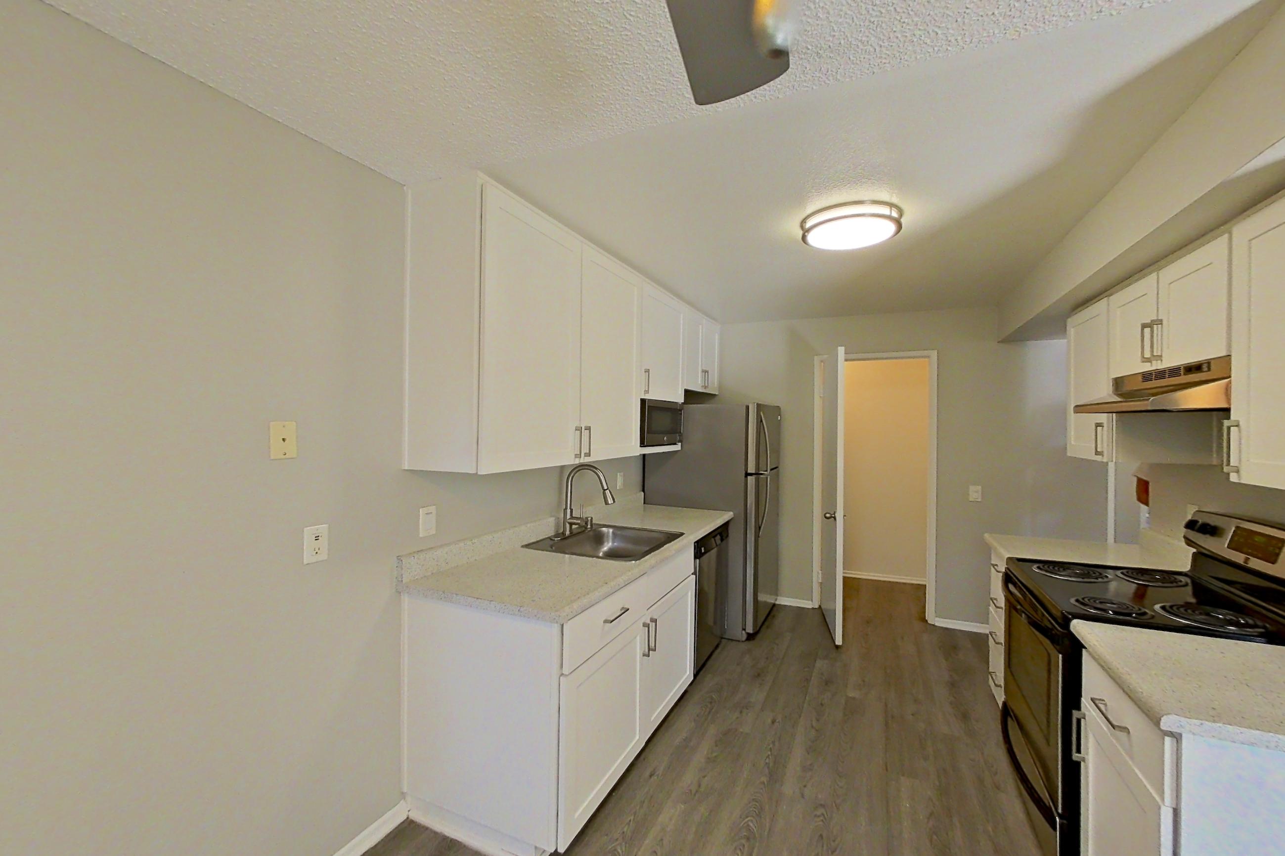Dining area with dishwasher, electric range, light countertops, light stone countertops, light wood-finish flooring, refrigerator, and stainless steel appliances, Apartment 06-05 at Avana Rancho Cucamonga
