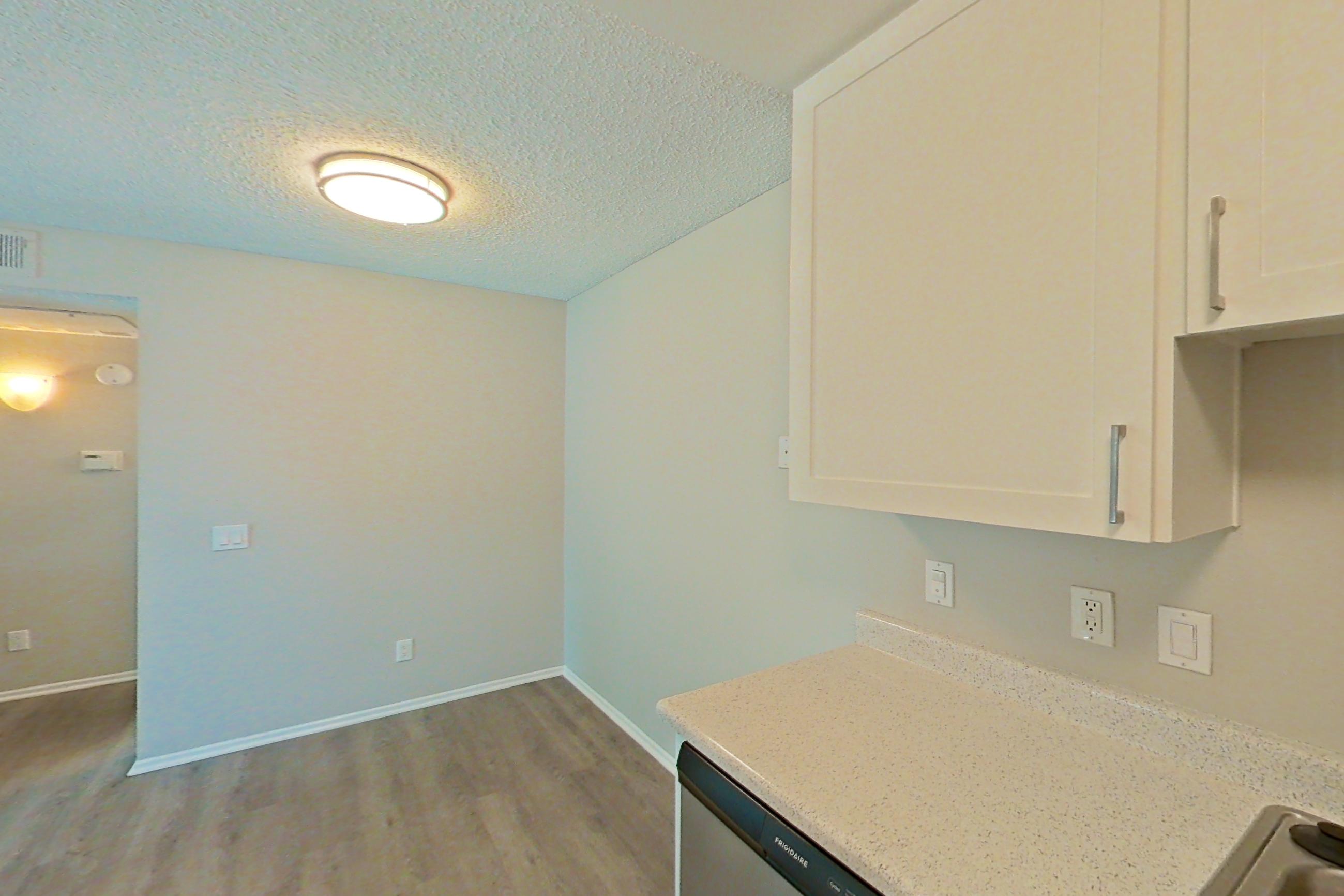 Kitchen with dishwasher, electric range, light countertops, light wood-finish flooring, oven/range, refrigerator, and stainless steel appliances, Apartment 07-06 at Avana Rancho Cucamonga