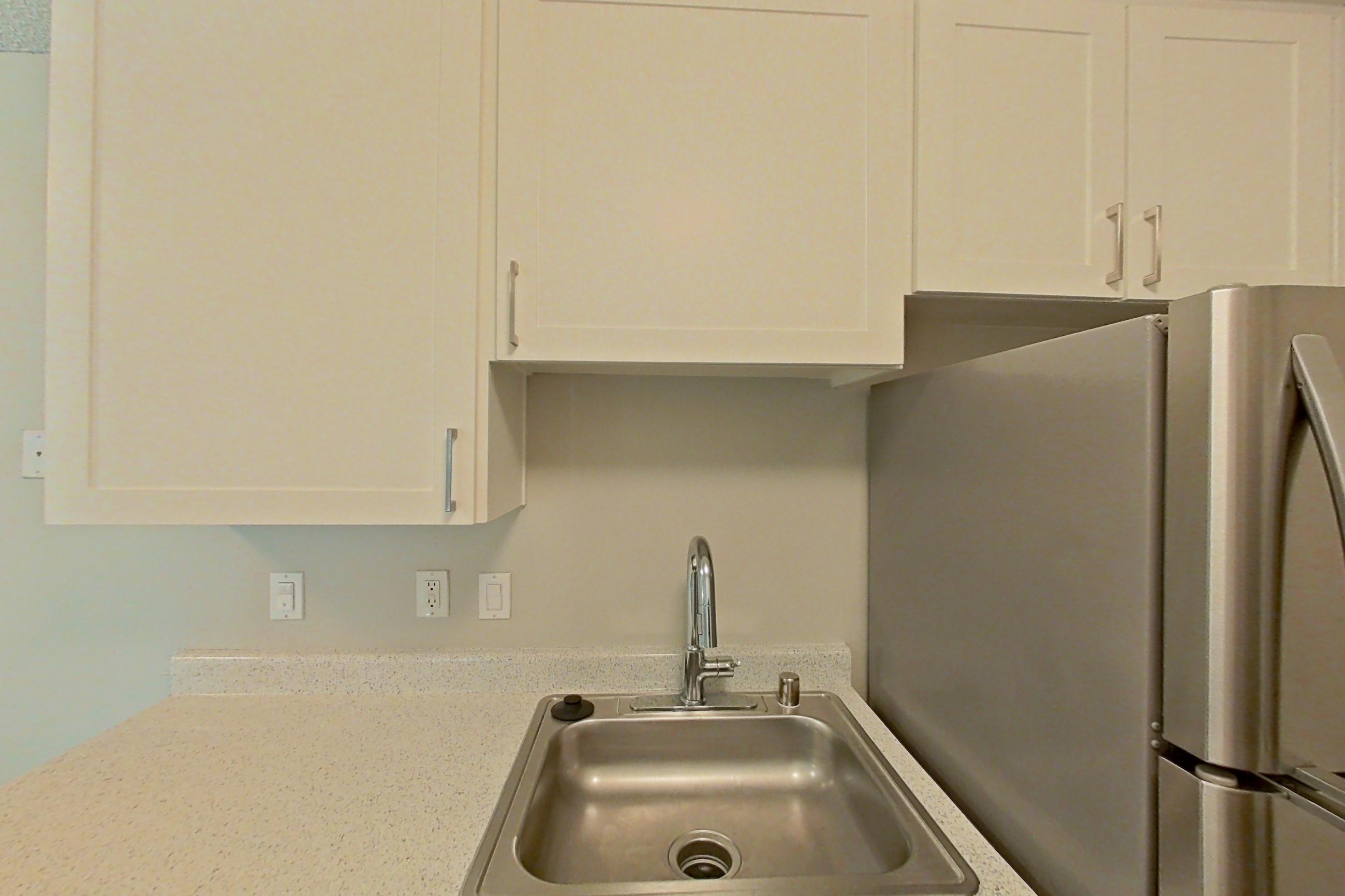 Kitchen with dishwasher, electric range, light countertops, light wood-finish flooring, oven/range, refrigerator, and stainless steel appliances, Apartment 07-06 at Avana Rancho Cucamonga