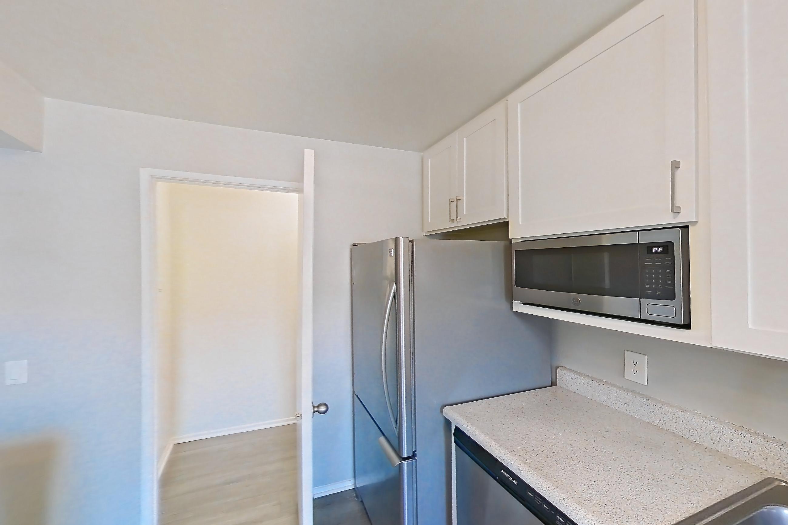 Kitchen with electric range, light stone countertops, oven/range, refrigerator, and stainless steel appliances, Apartment 08-03 at Avana Rancho Cucamonga