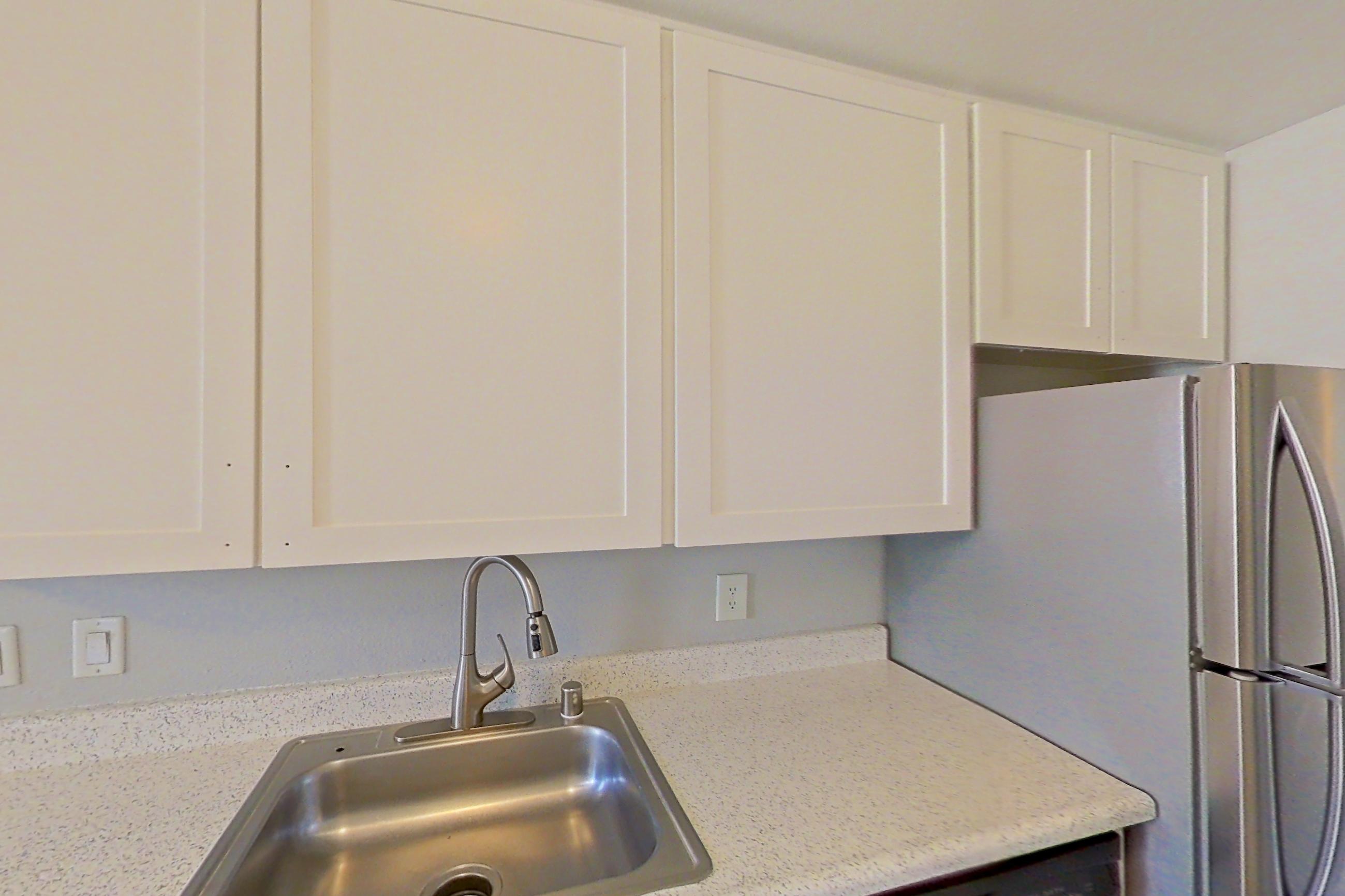 Kitchen with dishwasher, electric range, light stone countertops, light wood-finish flooring, microwave, oven/range, refrigerator, and stainless steel appliances, Apartment 09-01 at Avana Rancho Cucamonga