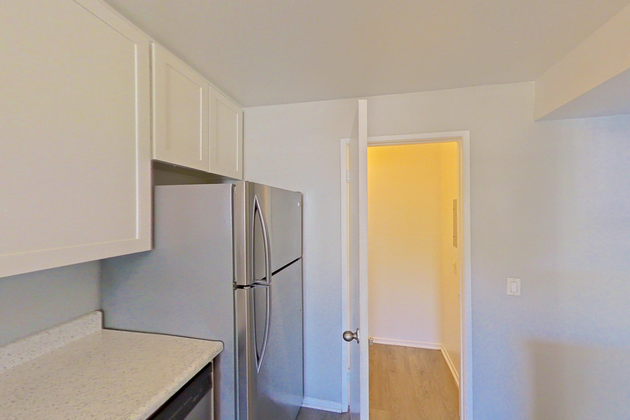 Kitchen with dishwasher, electric range, light stone countertops, light wood-finish flooring, microwave, oven/range, refrigerator, and stainless steel appliances, Apartment 09-01 at Avana Rancho Cucamonga
