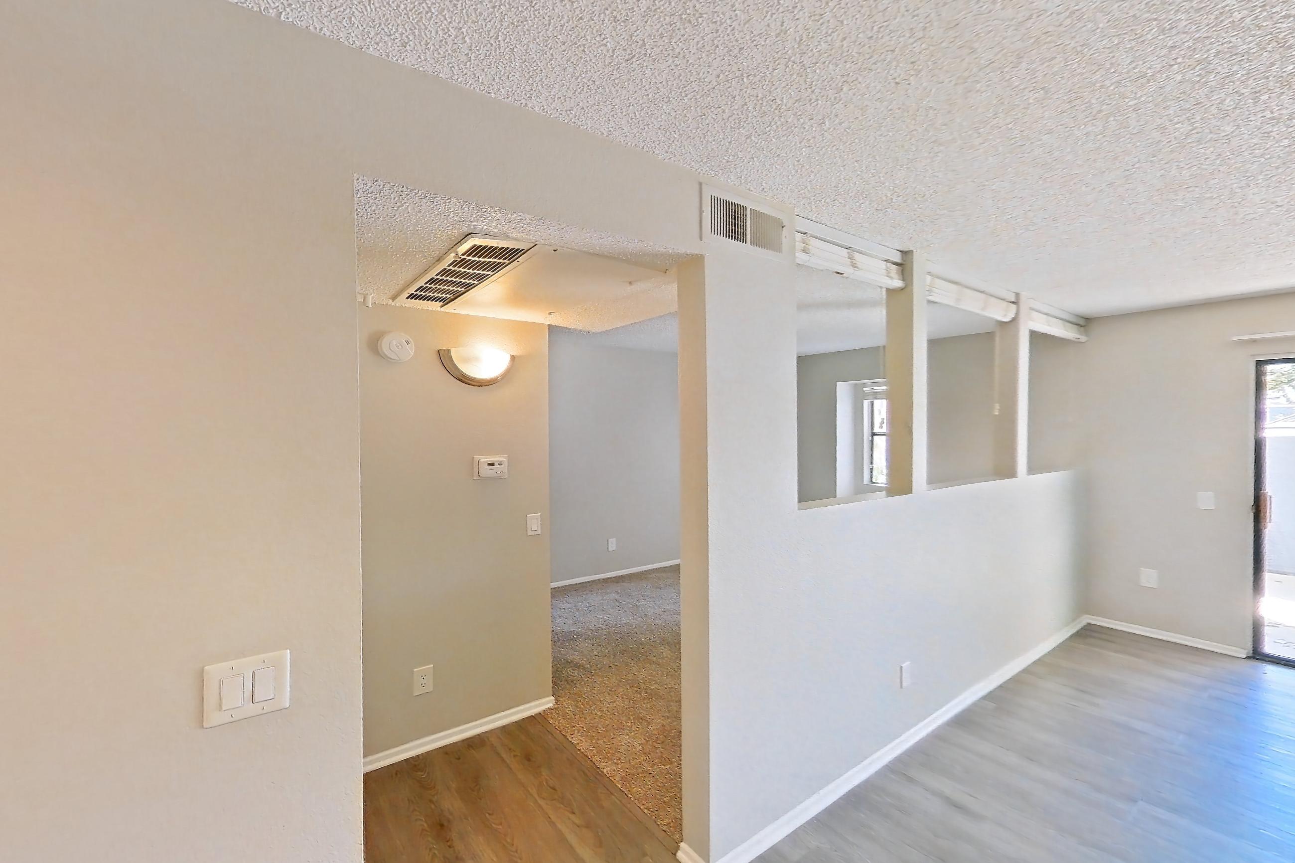 Dining room with black appliances, dark wood-finish flooring, dishwasher, electric range, light carpet, light countertops, light stone countertops, light wood-finish flooring, oven/range, refrigerator, and stainless steel appliances, Apartment 10-04 at Avana Rancho Cucamonga
