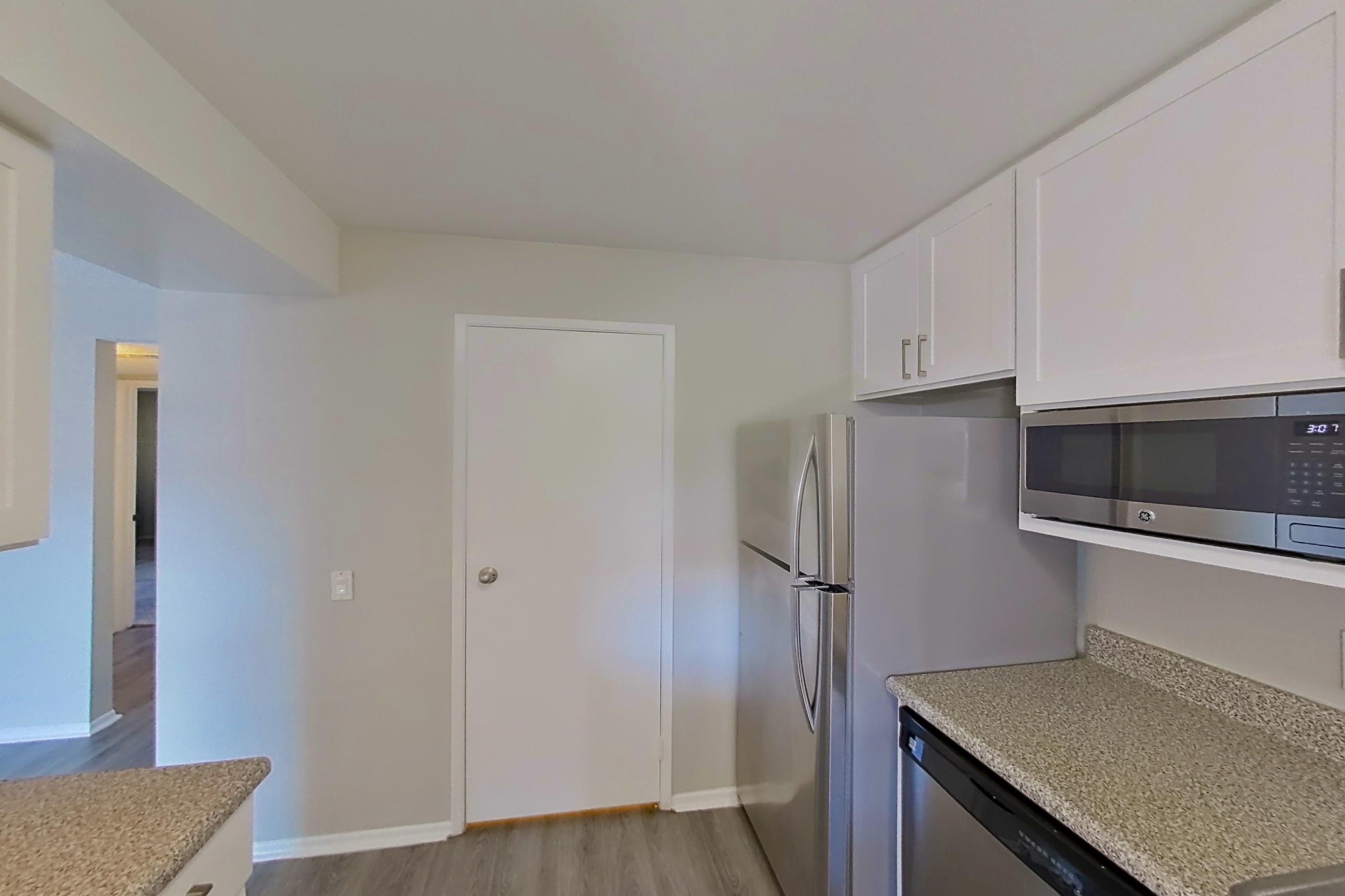 Kitchen with dishwasher, electric range, light countertops, light stone countertops, light wood-finish flooring, oven/range, and stainless steel appliances, Apartment 10-11 at Avana Rancho Cucamonga