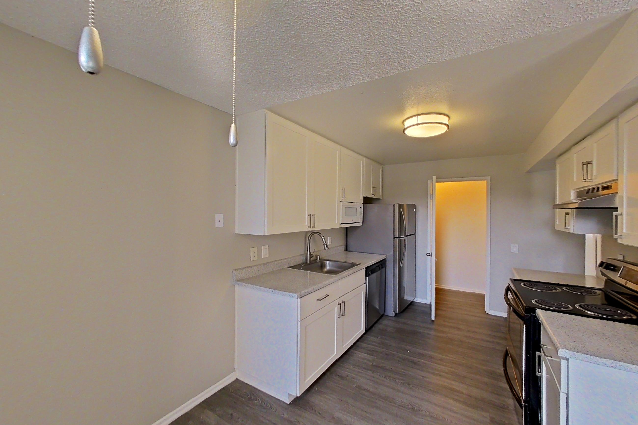 Dining area with dishwasher, electric range, light countertops, oven/range, refrigerator, and stainless steel appliances, Apartment 11-01 at Avana Rancho Cucamonga