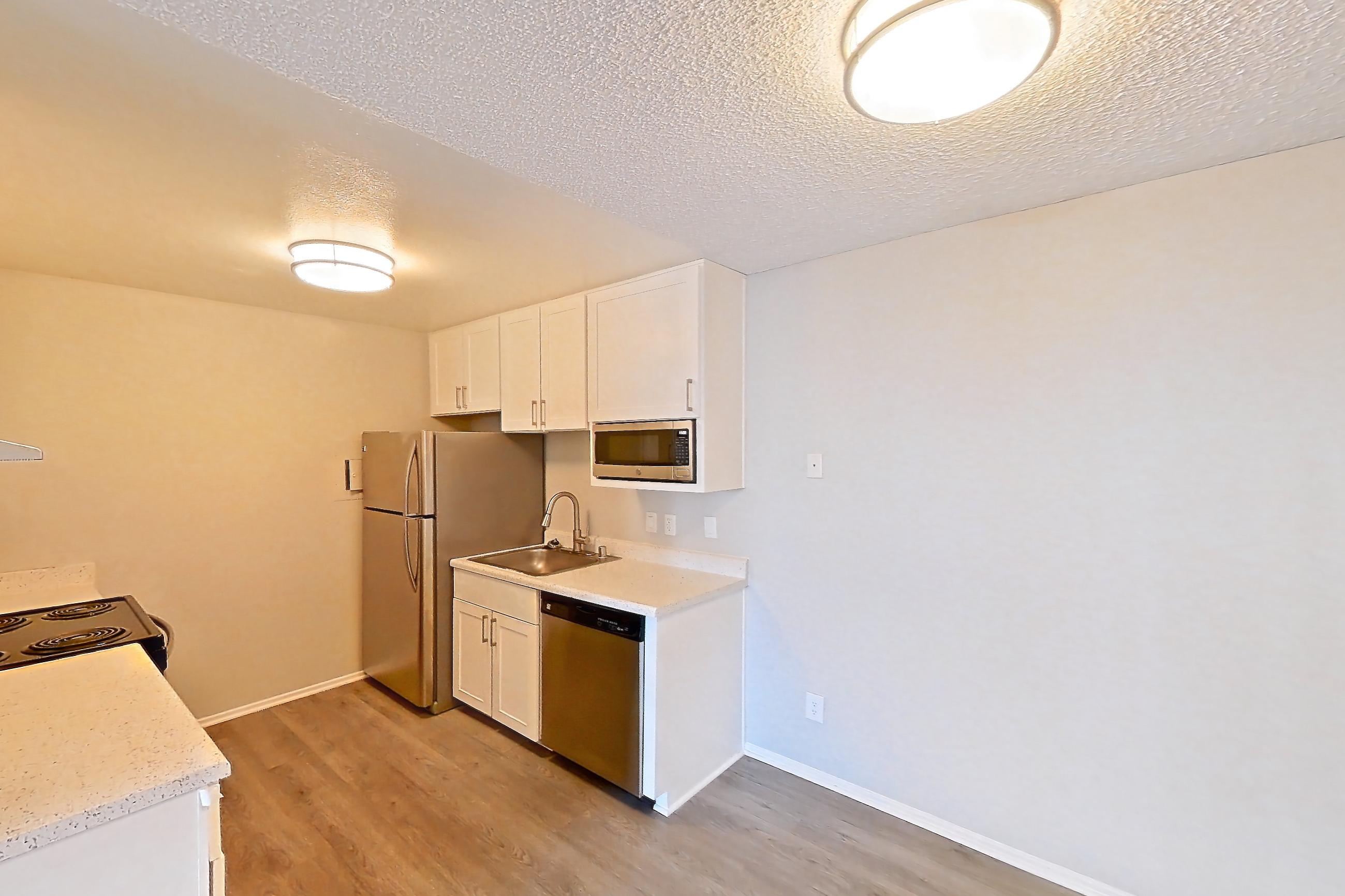 Dining room with dishwasher, light countertops, light wood-finish flooring, and stainless steel appliances, Apartment 12-08 at Avana Rancho Cucamonga