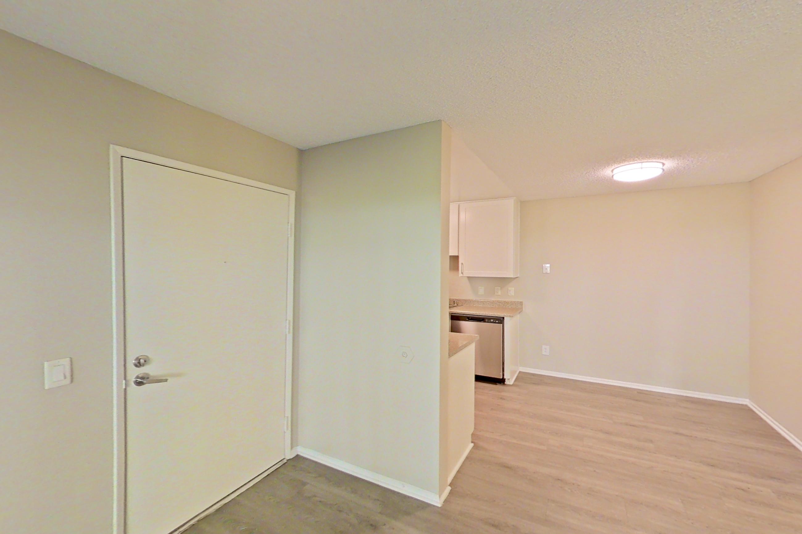 Living room with dishwasher, light wood-finish flooring, and stainless steel appliances, Apartment 13-04 at Avana Rancho Cucamonga