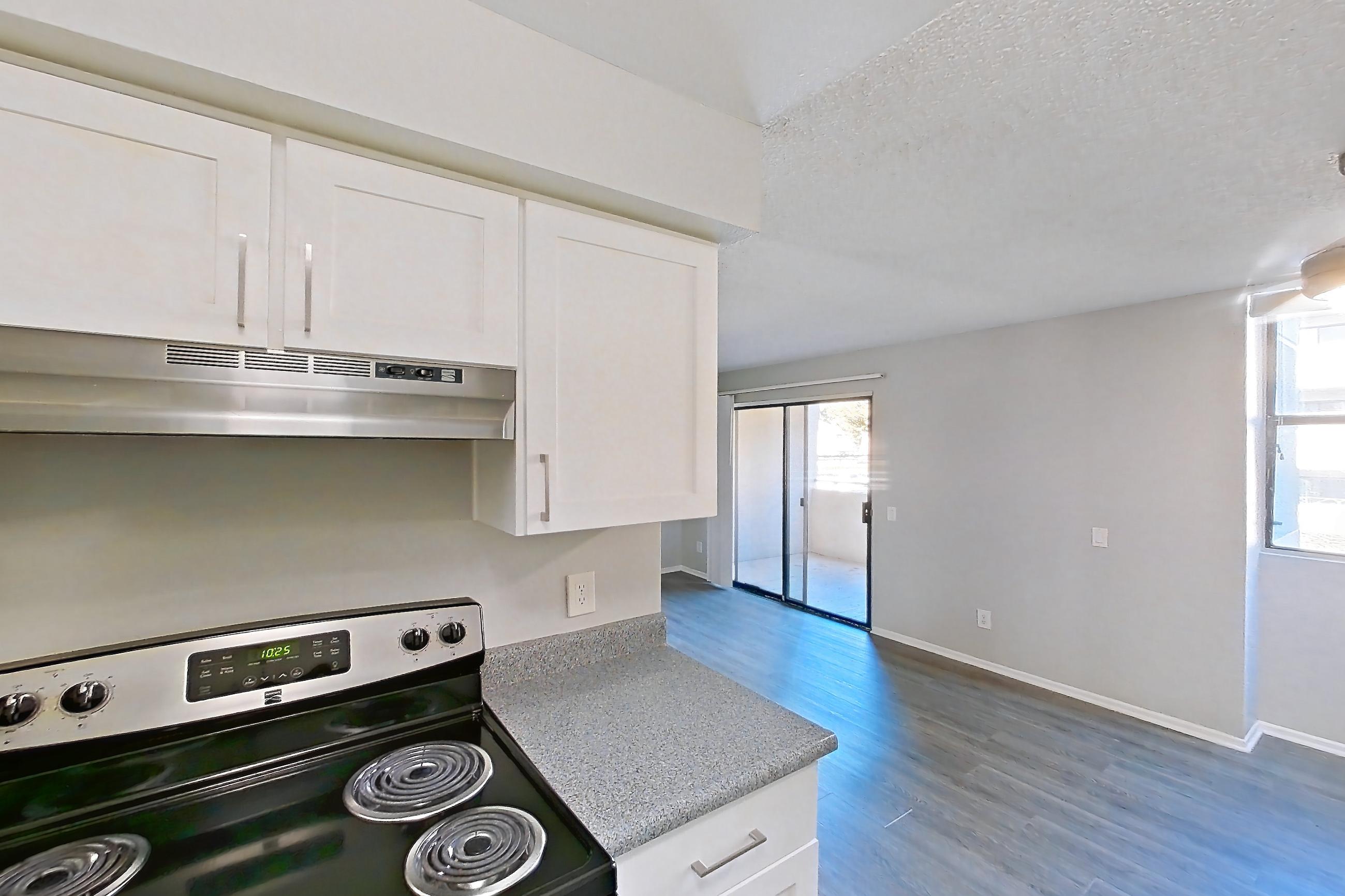 Kitchen with electric range, light countertops, light wood-finish flooring, oven/range, and stainless steel appliances, Apartment 13-05 at Avana Rancho Cucamonga