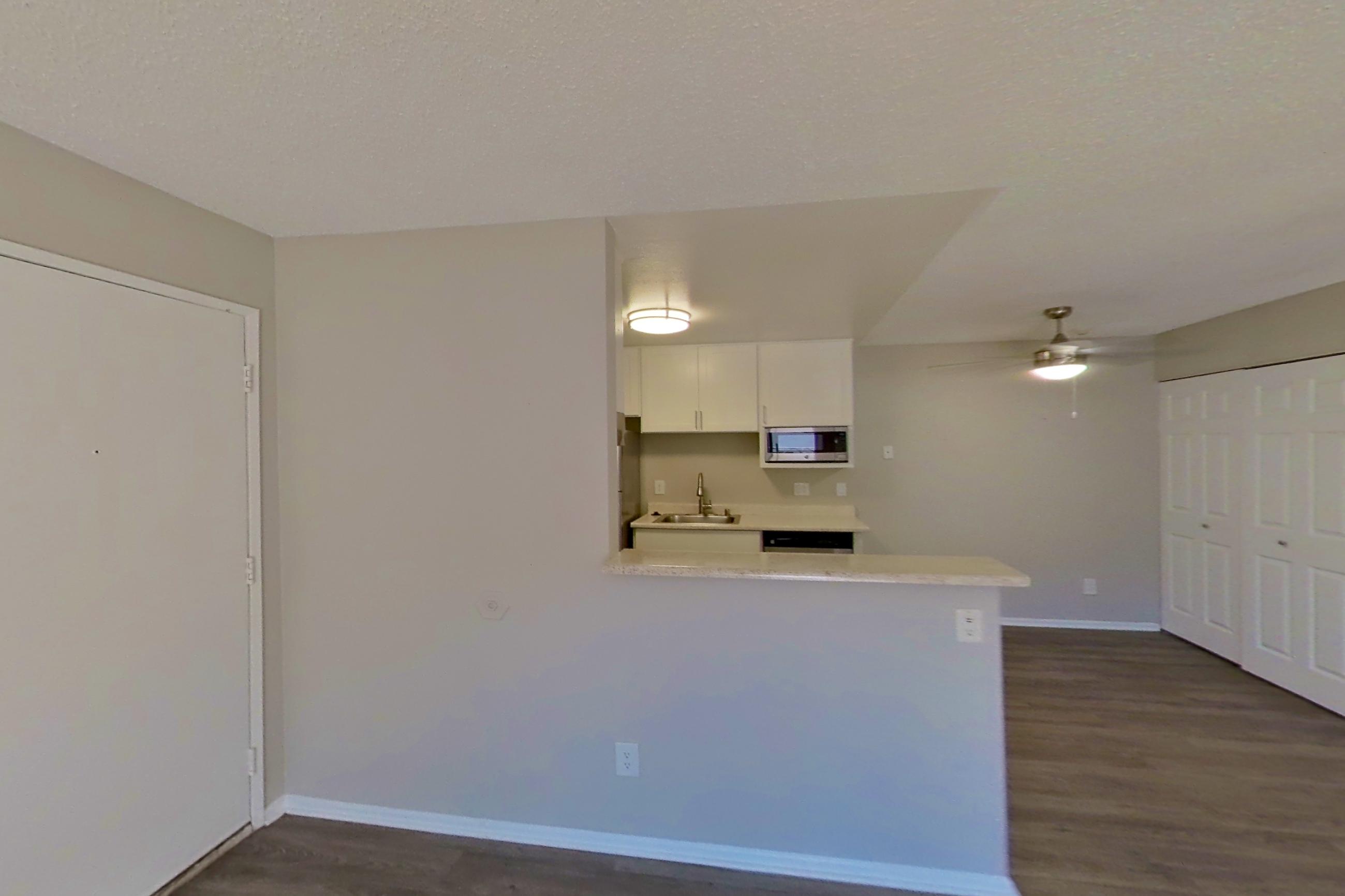 Living space with dark wood-finish flooring and light countertops, Apartment 14-02 at Avana Rancho Cucamonga