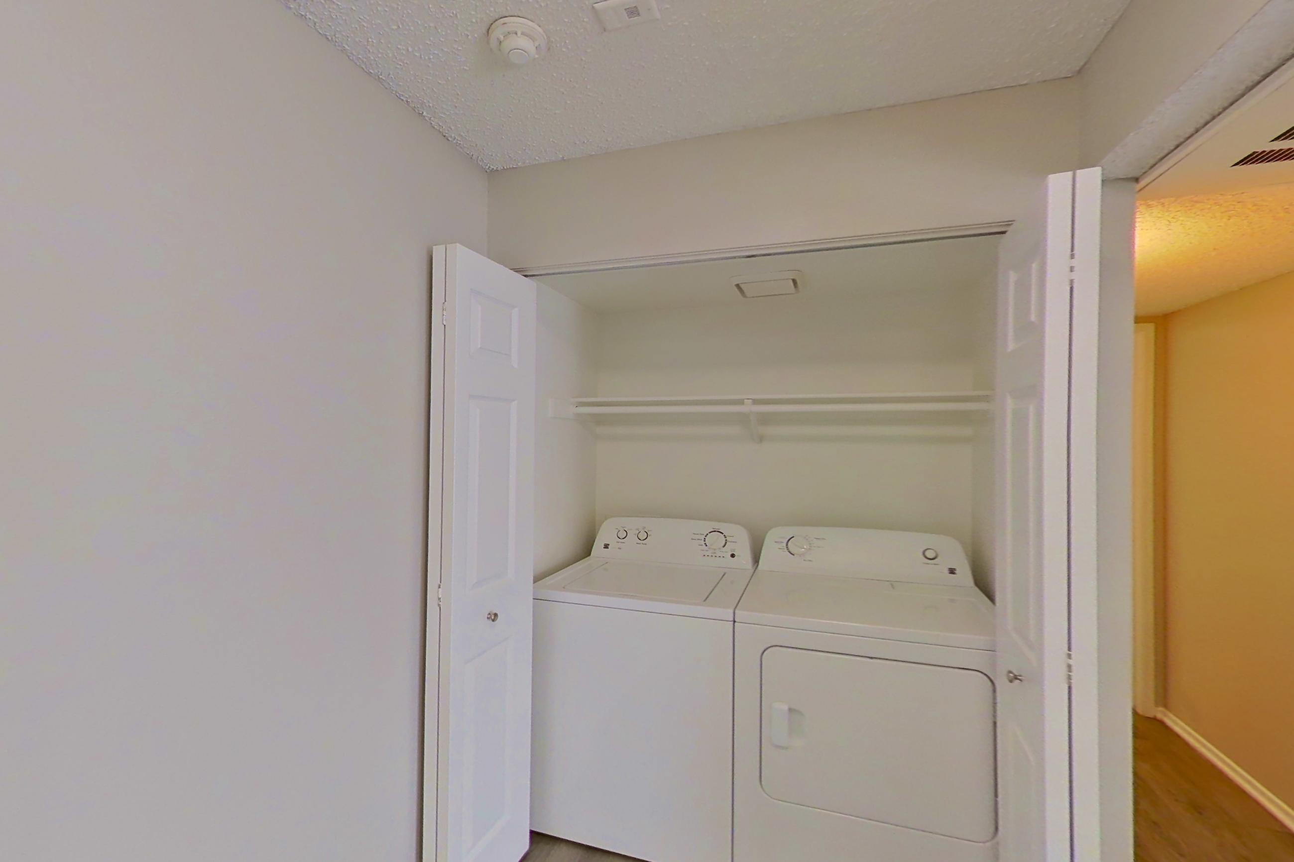 Dining space with dishwasher, electric range, in-unit laundry, light countertops, light wood-finish flooring, oven/range, and stainless steel appliances, Apartment 15-06 at Avana Rancho Cucamonga