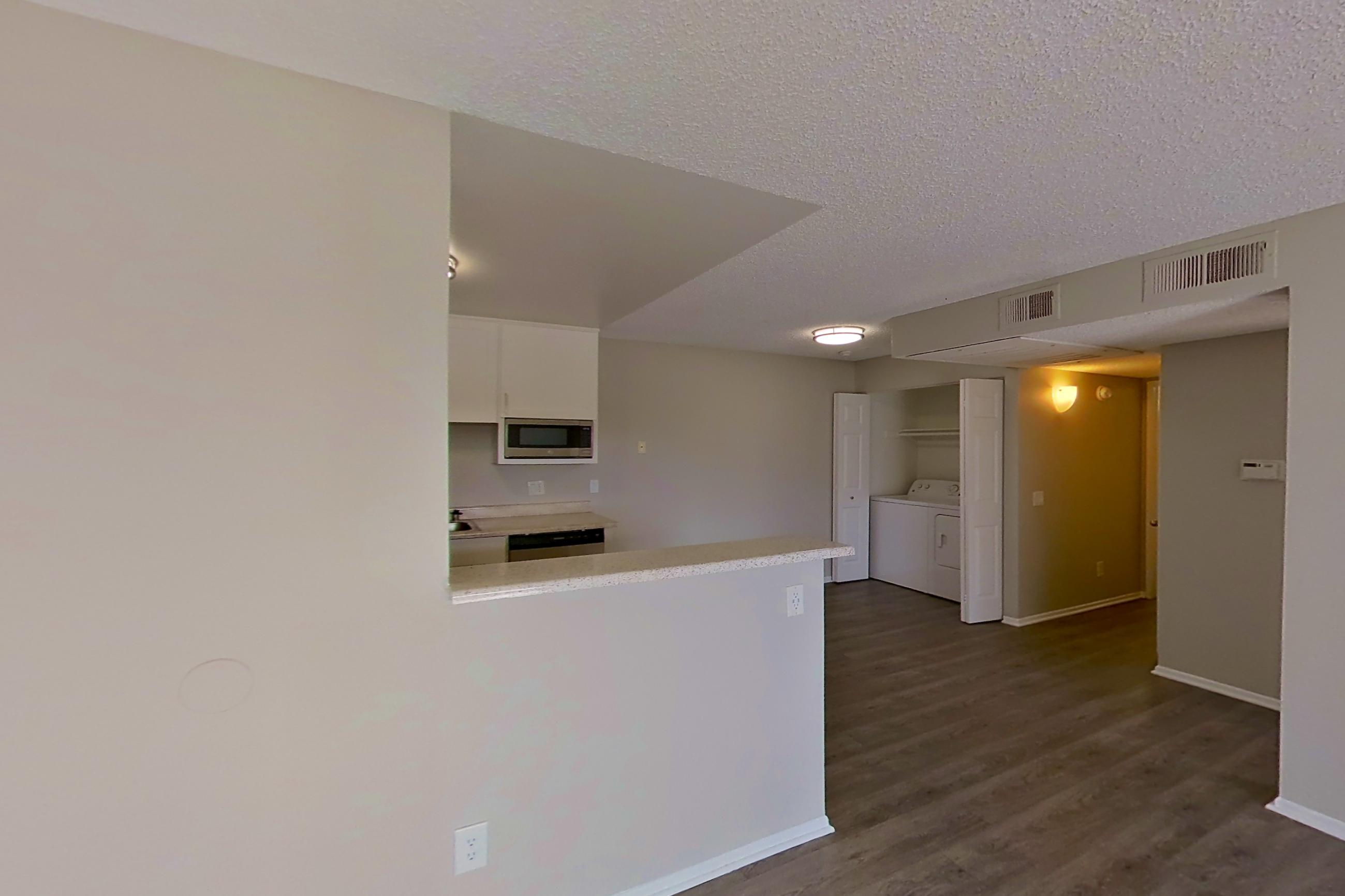 Living room with dishwasher and stainless steel appliances, Apartment 15-06 at Avana Rancho Cucamonga