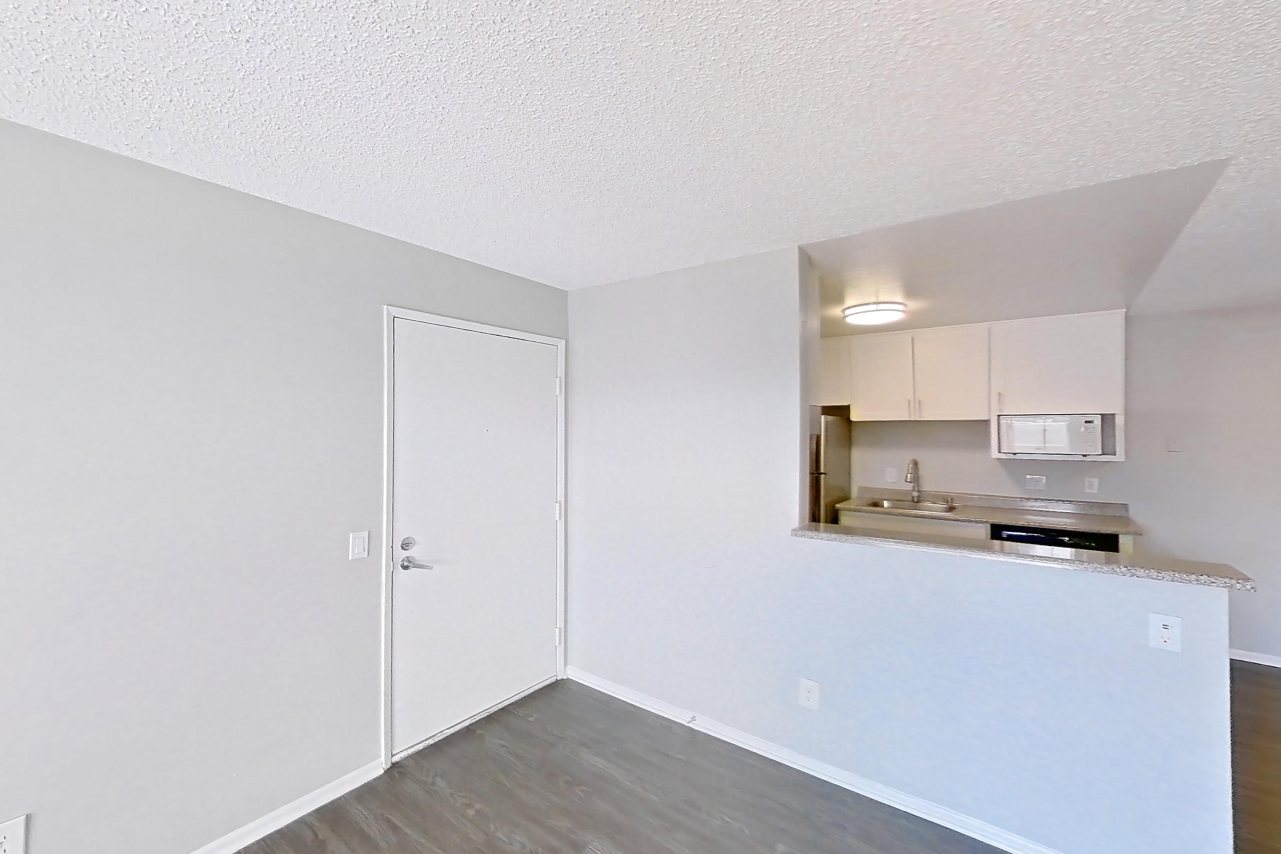 Living room with dark wood-finish flooring, Apartment 15-18 at Avana Rancho Cucamonga