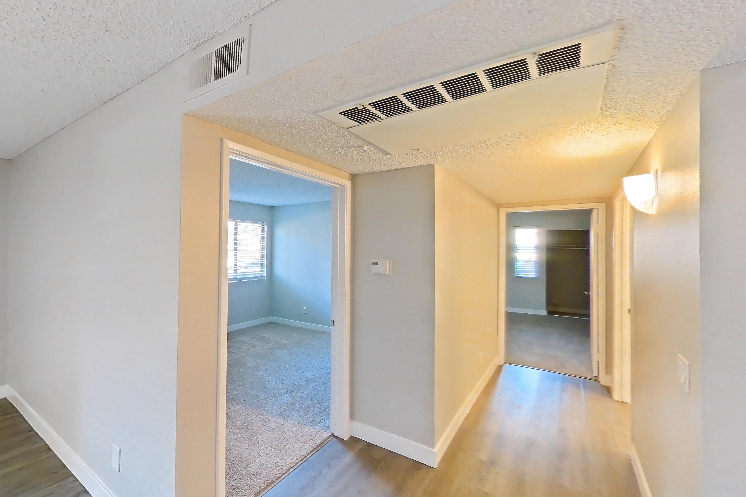 Dining room with black appliances, dishwasher, electric range, light carpet, light countertops, light stone countertops, light wood-finish flooring, oven/range, refrigerator, and stainless steel appliances, Apartment 16-01 at Avana Rancho Cucamonga