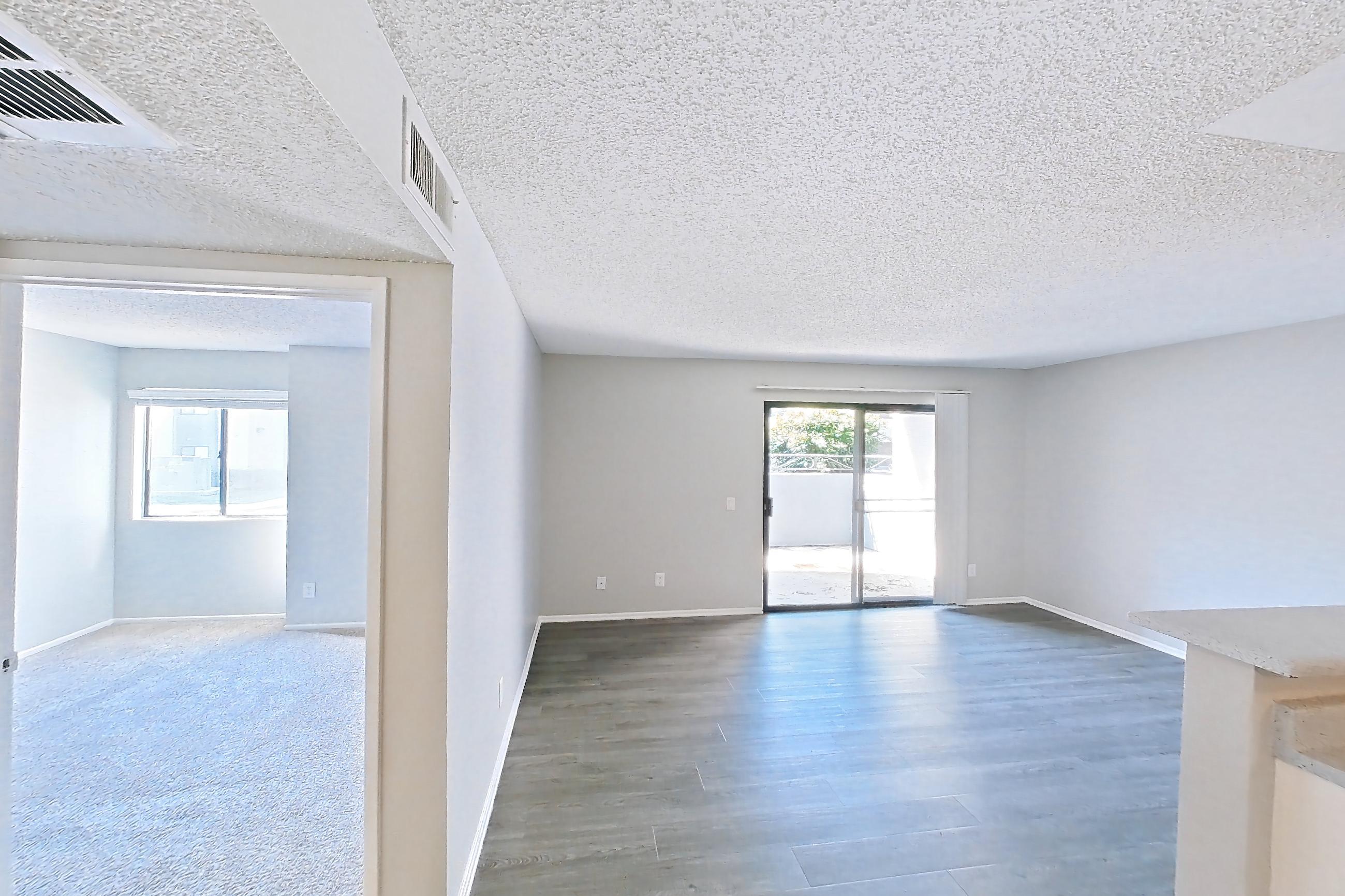 Dining room with black appliances, dark carpet, dark wood-finish flooring, dishwasher, electric range, light countertops, light wood-finish flooring, oven/range, refrigerator, and stainless steel appliances, Apartment 16-03 at Avana Rancho Cucamonga