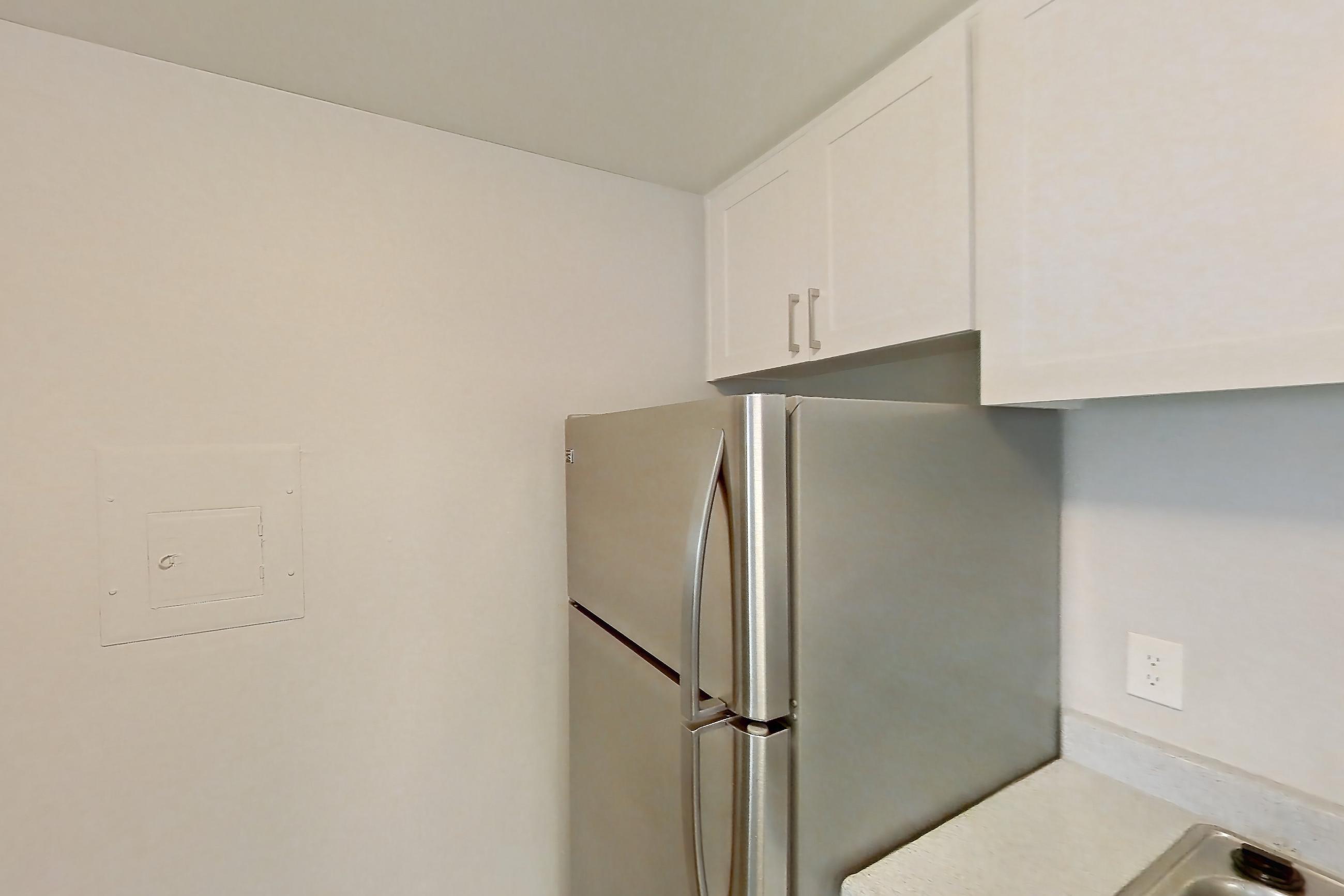 Kitchen with dishwasher, electric range, light countertops, light wood-finish flooring, microwave, oven/range, refrigerator, and stainless steel appliances, Apartment 16-03 at Avana Rancho Cucamonga