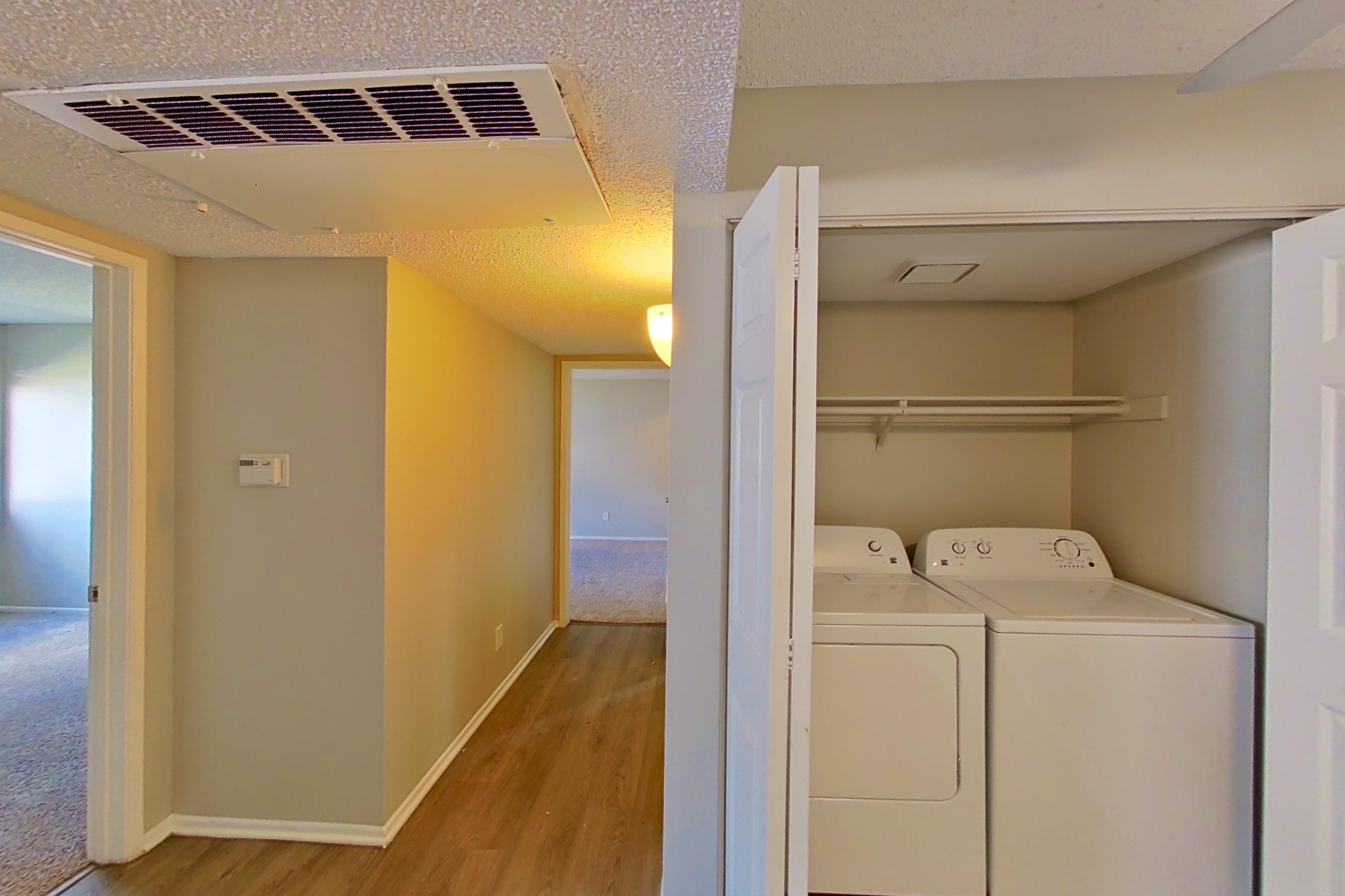 Dining area with dishwasher, electric range, in-unit laundry, light stone countertops, light wood-finish flooring, microwave, refrigerator, and stainless steel appliances, Apartment 16-08 at Avana Rancho Cucamonga