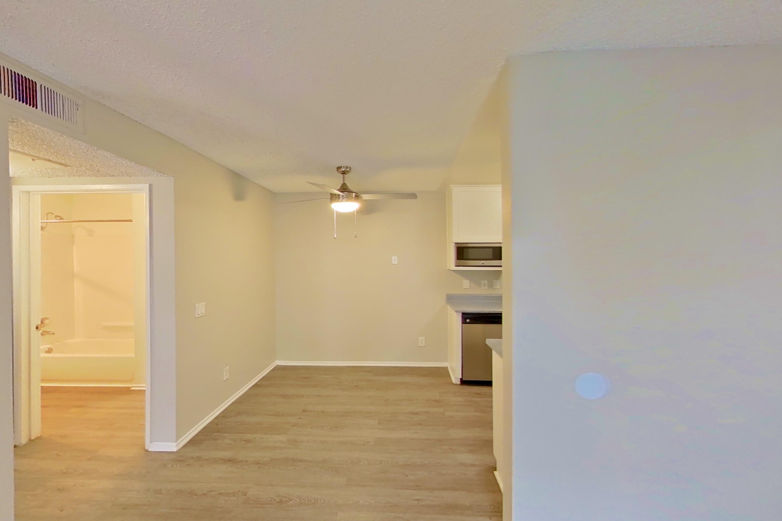 Living room with dishwasher, light wood-finish flooring, and stainless steel appliances, Apartment 18-06 at Avana Rancho Cucamonga