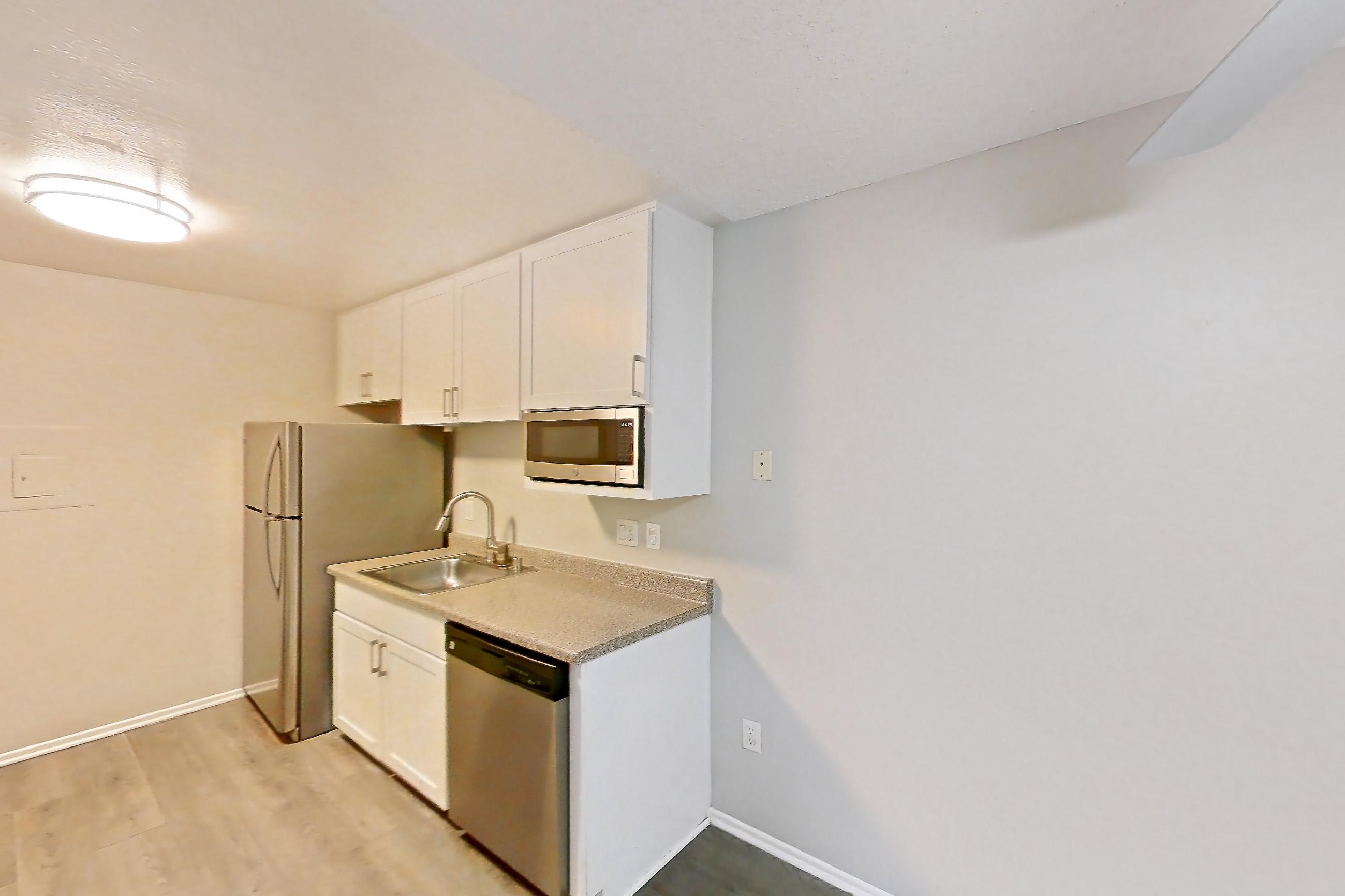 Dining area with dishwasher, electric range, light countertops, light wood-finish flooring, oven/range, refrigerator, stainless steel appliances, and white appliances, Apartment 19-02 at Avana Rancho Cucamonga