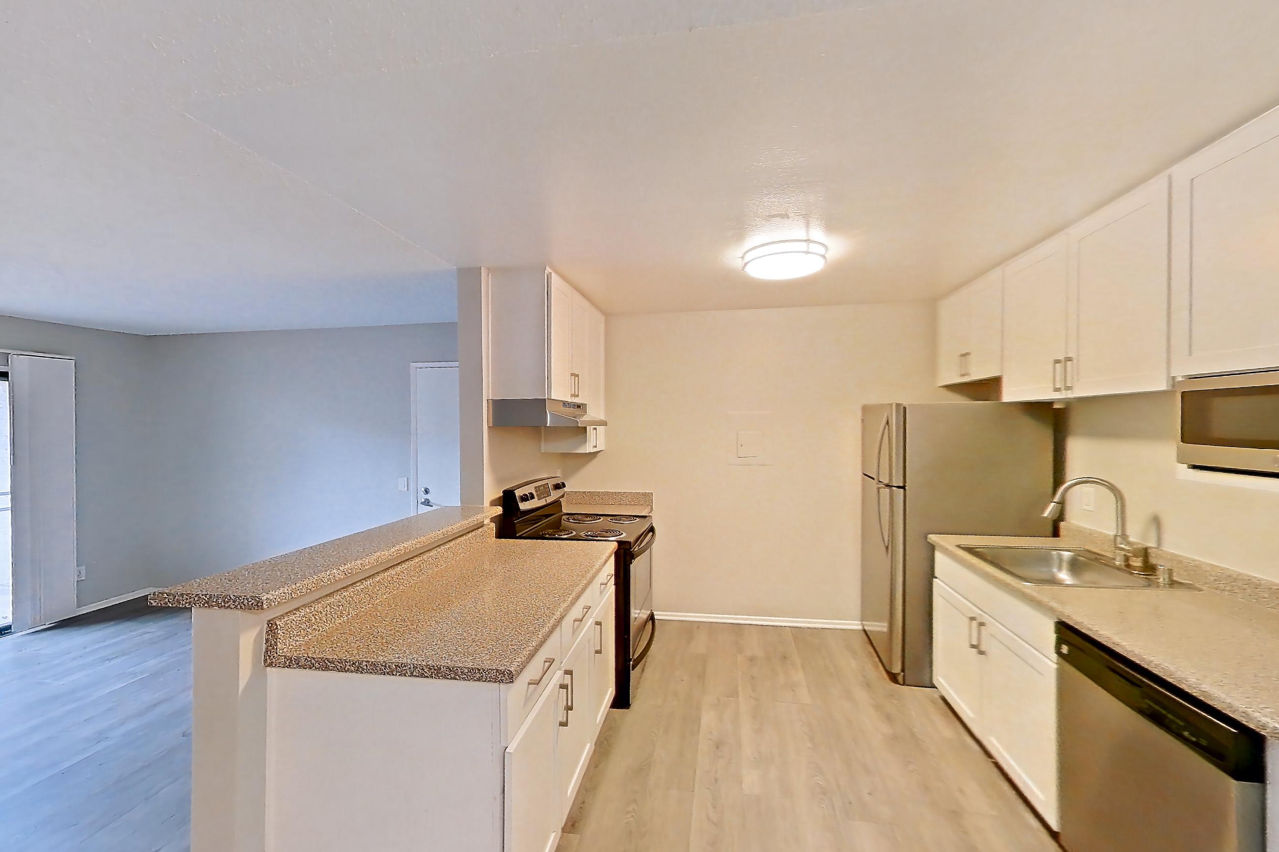 Dining area with dishwasher, electric range, light countertops, light wood-finish flooring, oven/range, refrigerator, stainless steel appliances, and white appliances, Apartment 19-02 at Avana Rancho Cucamonga