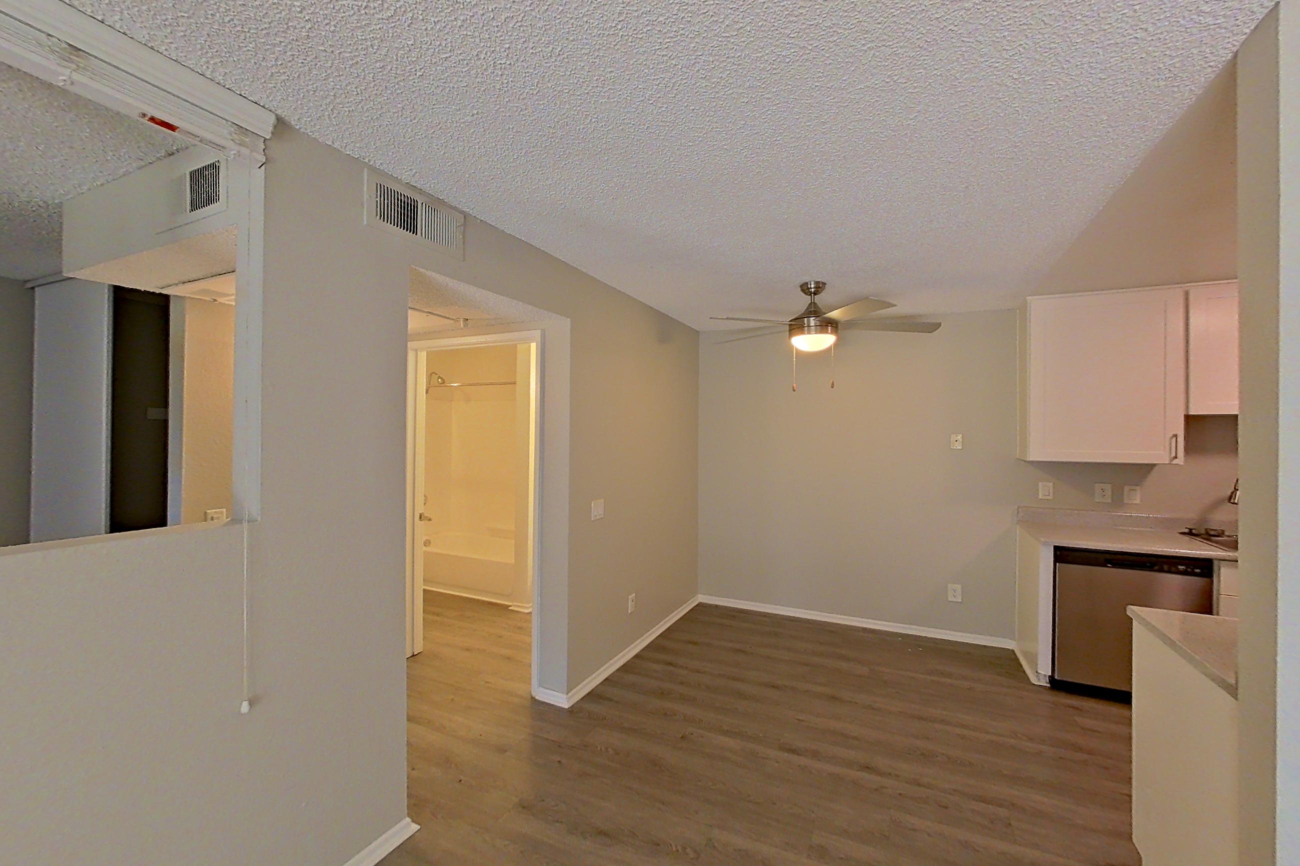 Living room with dark wood-finish flooring, dishwasher, and stainless steel appliances, Apartment 02-02 at Avana Rancho Cucamonga