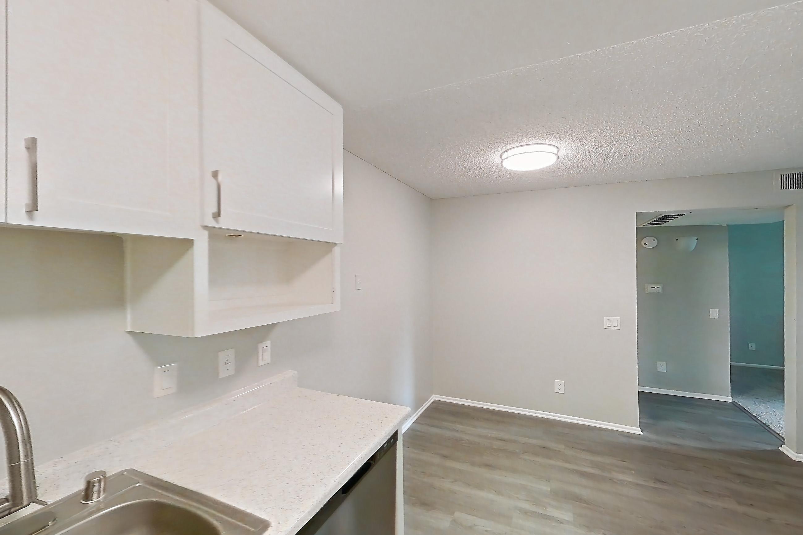 Kitchen with dishwasher, electric range, light countertops, light stone countertops, light wood-finish flooring, oven/range, and stainless steel appliances, Apartment 02-12 at Avana Rancho Cucamonga