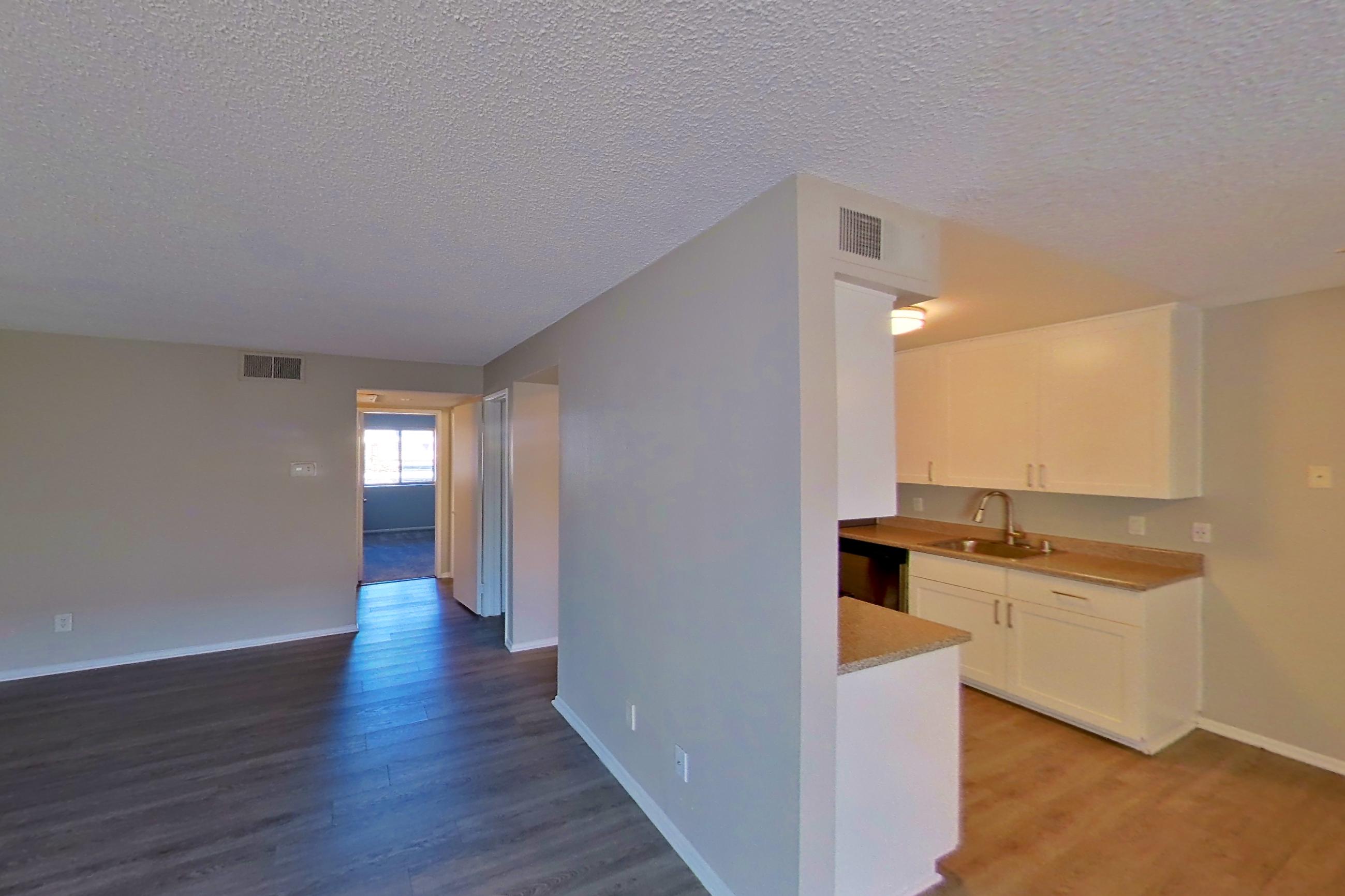 Living space with dark wood-finish flooring and light countertops, Apartment 07-03 at Avana Rancho Cucamonga