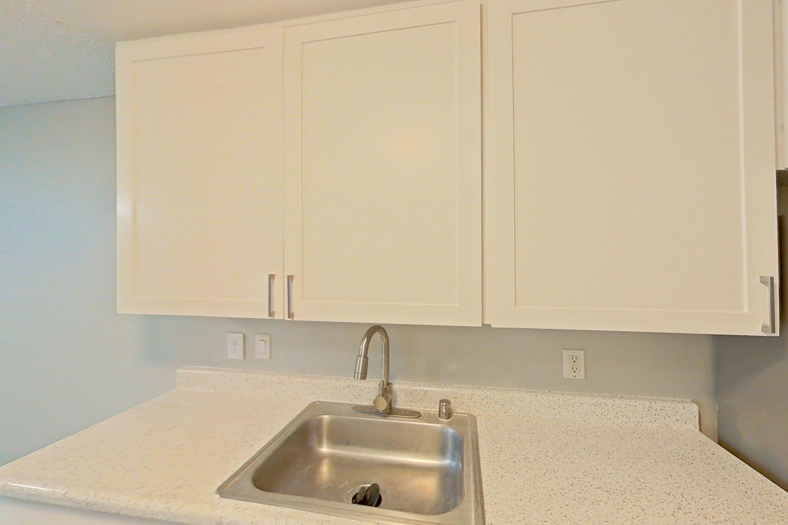 Kitchen with dishwasher, electric range, light stone countertops, light wood-finish flooring, microwave, oven/range, and stainless steel appliances, Apartment 09-05 at Avana Rancho Cucamonga