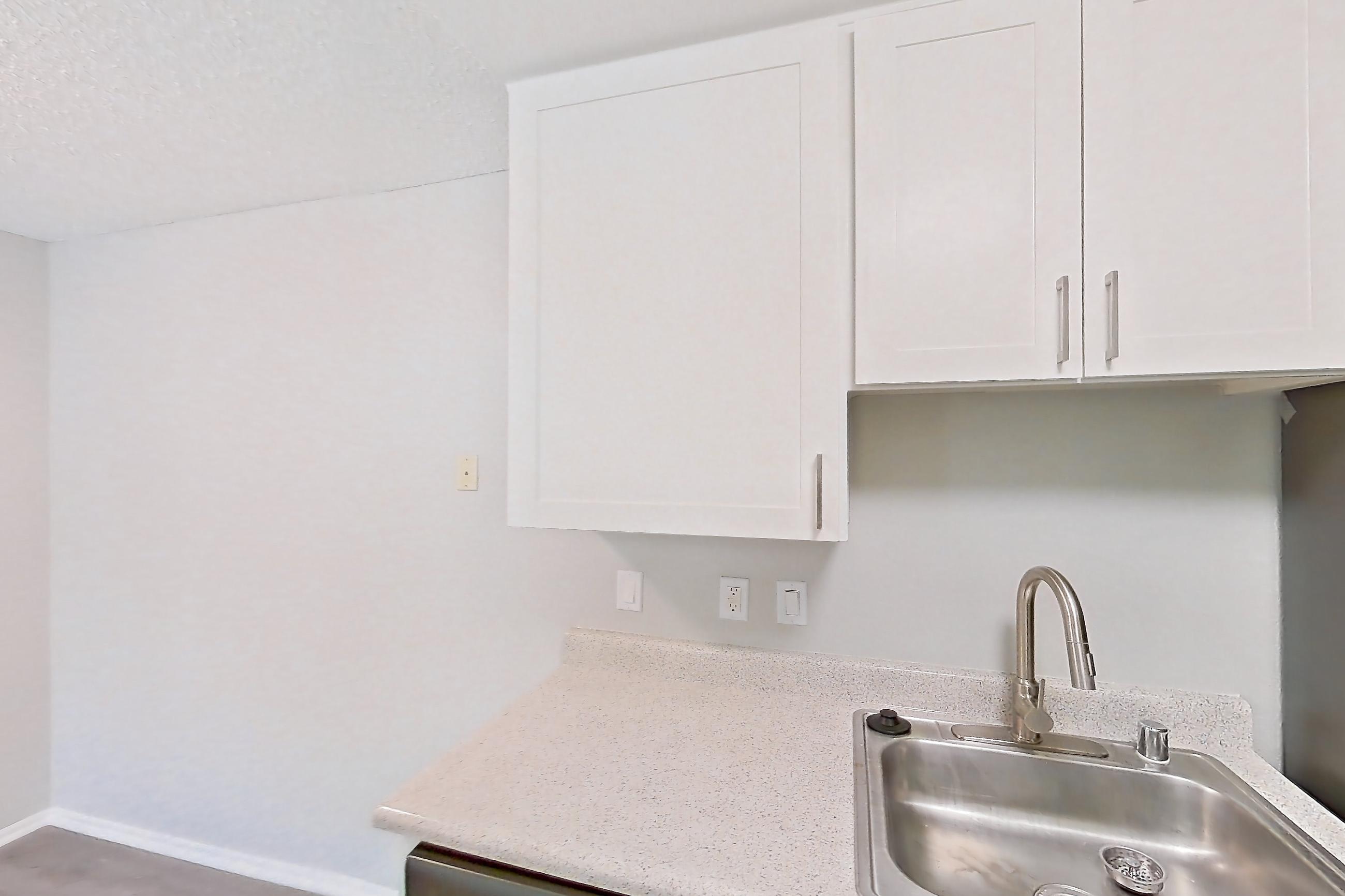 Kitchen with dishwasher, electric range, light countertops, light stone countertops, light wood-finish flooring, microwave, oven/range, and stainless steel appliances, Apartment 10-06 at Avana Rancho Cucamonga