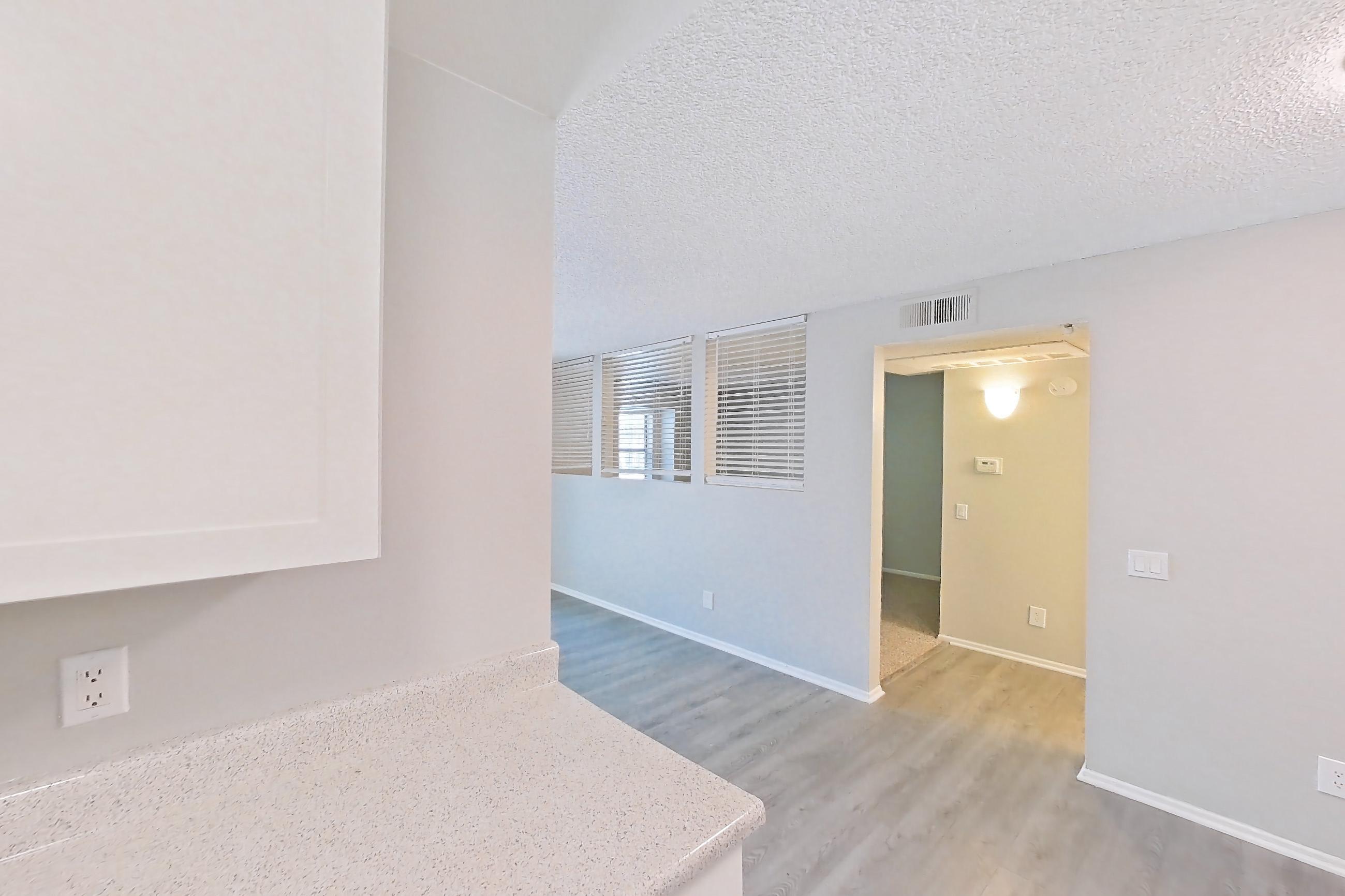 Kitchen with dishwasher, electric range, light countertops, light stone countertops, light wood-finish flooring, microwave, oven/range, and stainless steel appliances, Apartment 10-06 at Avana Rancho Cucamonga