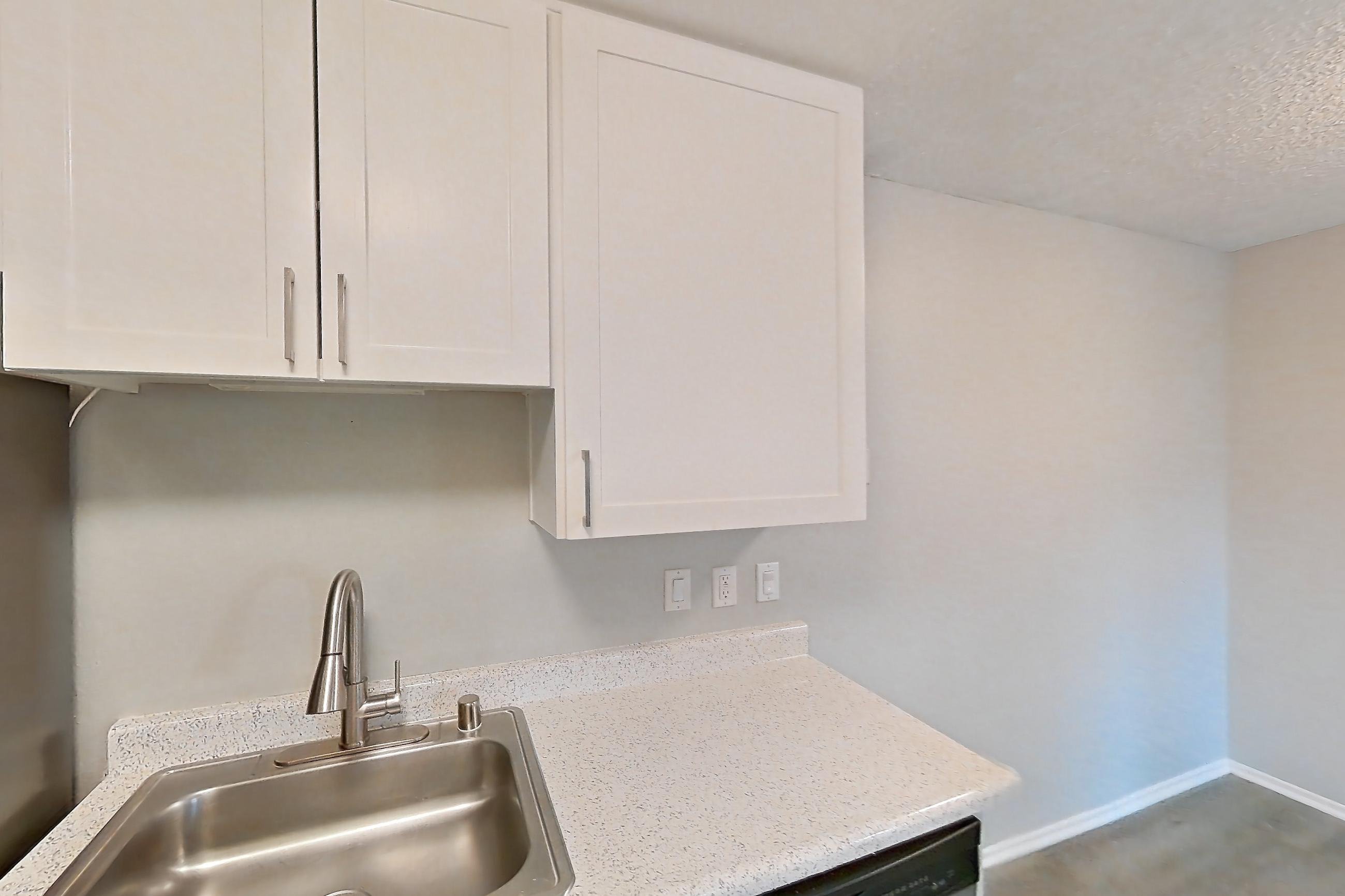 Kitchen with dishwasher, electric range, light stone countertops, light wood-finish flooring, microwave, oven/range, and stainless steel appliances, Apartment 11-04 at Avana Rancho Cucamonga