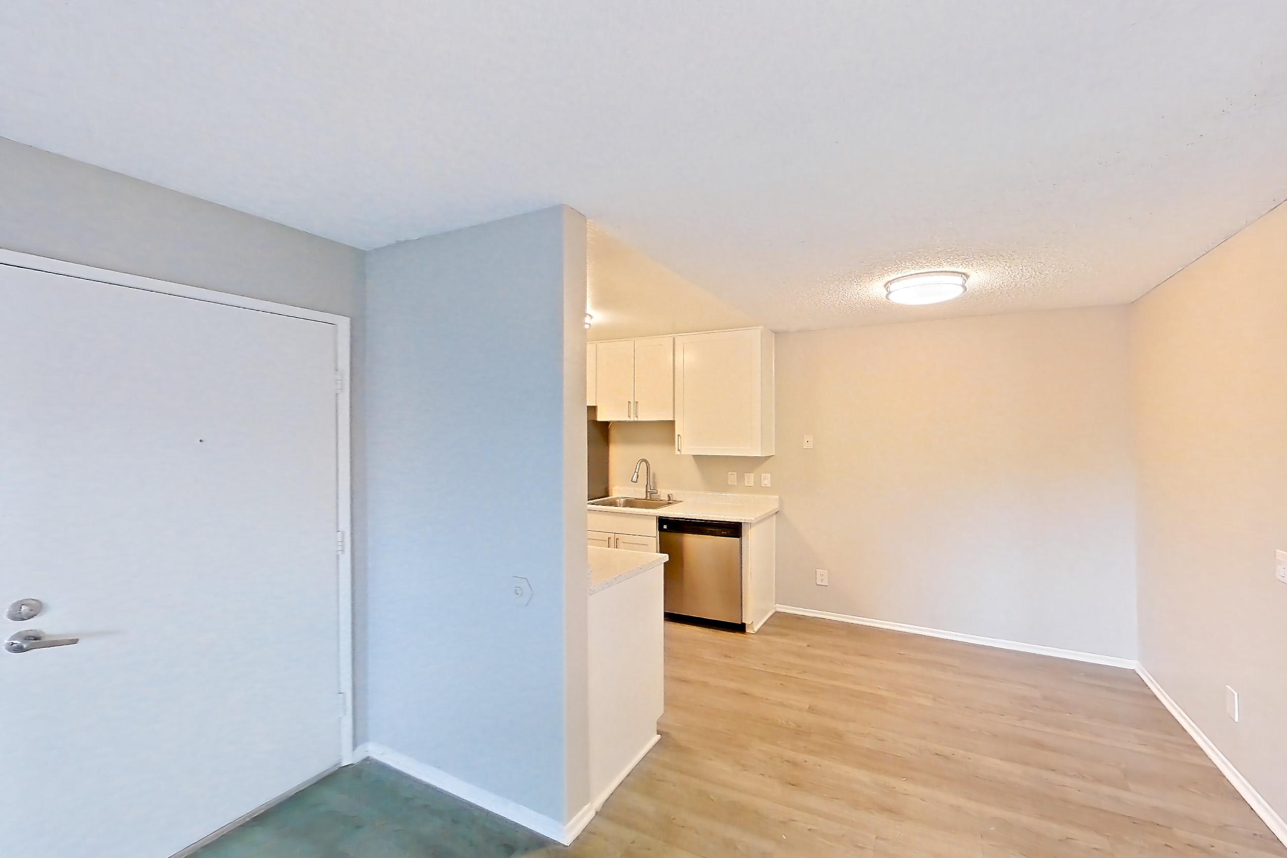 Living room with dishwasher, light wood-finish flooring, and stainless steel appliances, Apartment 11-04 at Avana Rancho Cucamonga